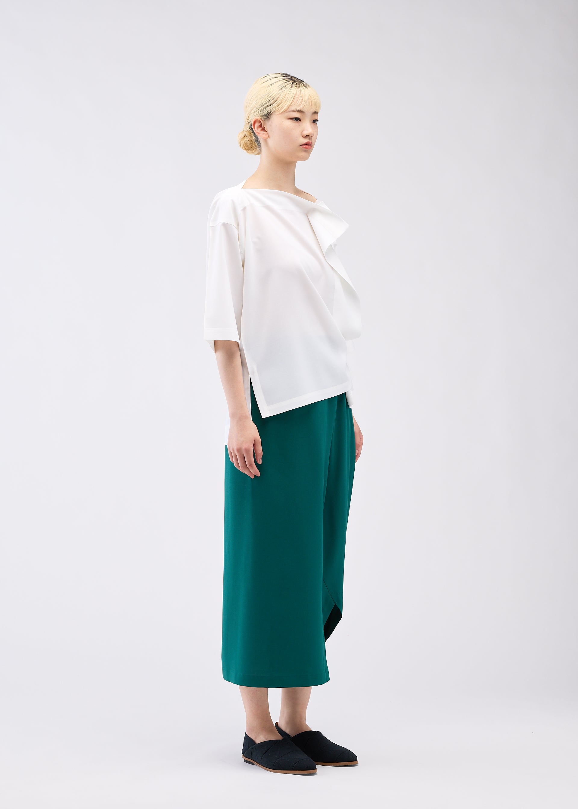 A model wears the 132 5. ISSEY MIYAKE FLAT ONE TUCK T shirt.