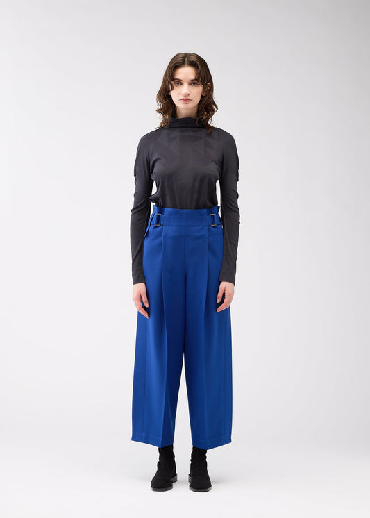 A model wears the 132 5. ISSEY MIYAKE WOOL LIKE FLAT TUCK trousers.