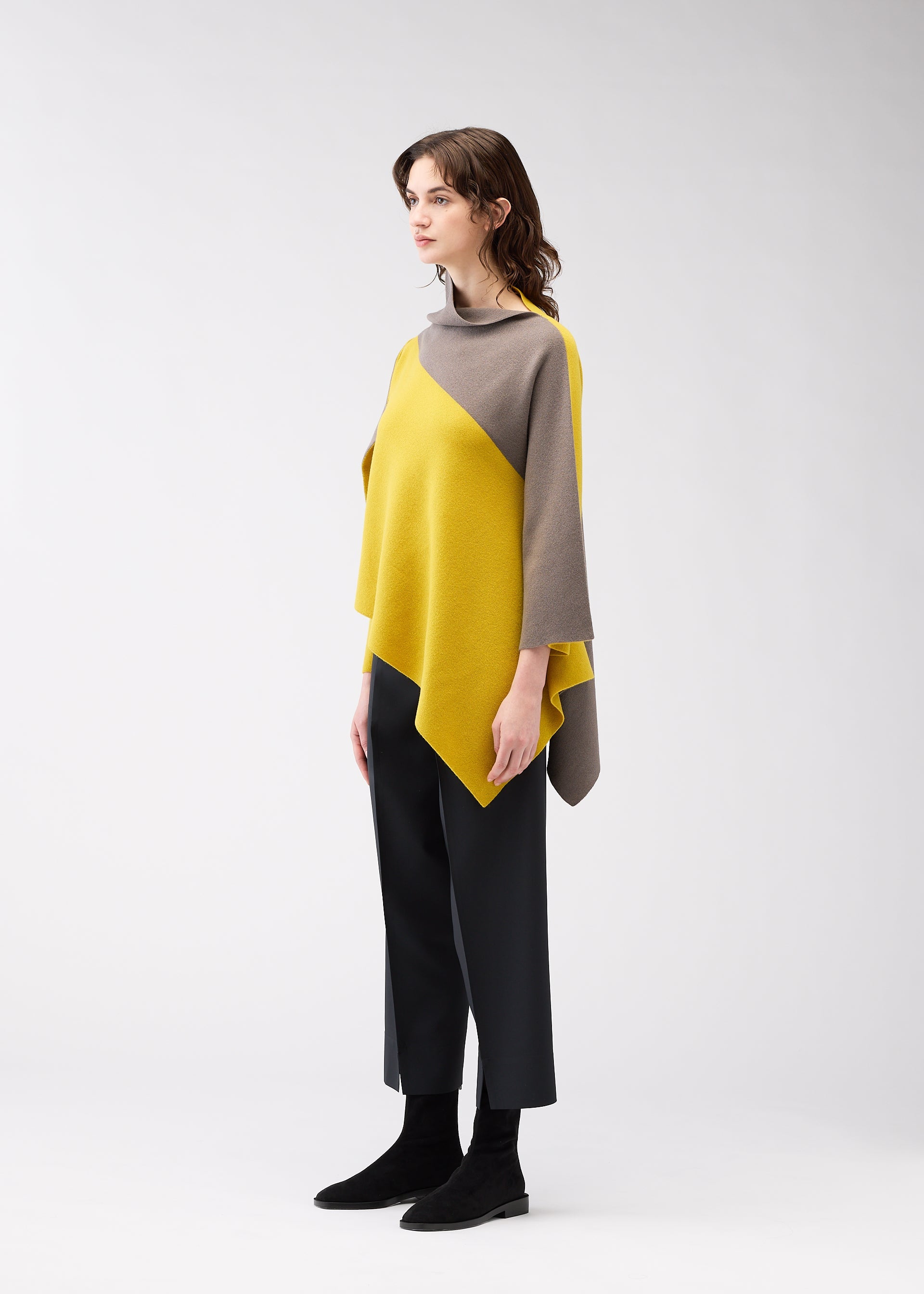 A model wears the 132 5. ISSEY MIYAKE POSITIONED KNIT top.