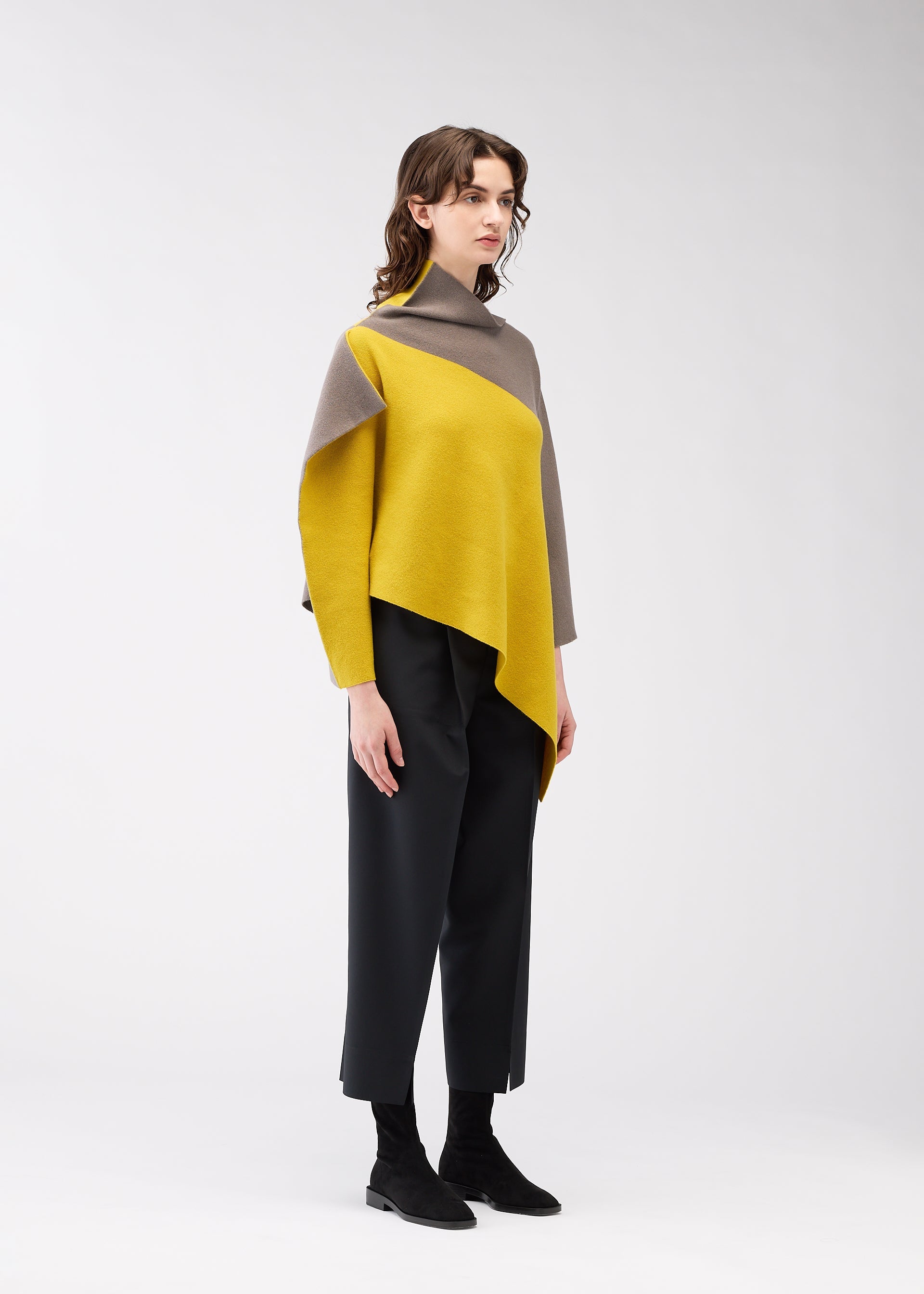 A model wears the 132 5. ISSEY MIYAKE POSITIONED KNIT top.