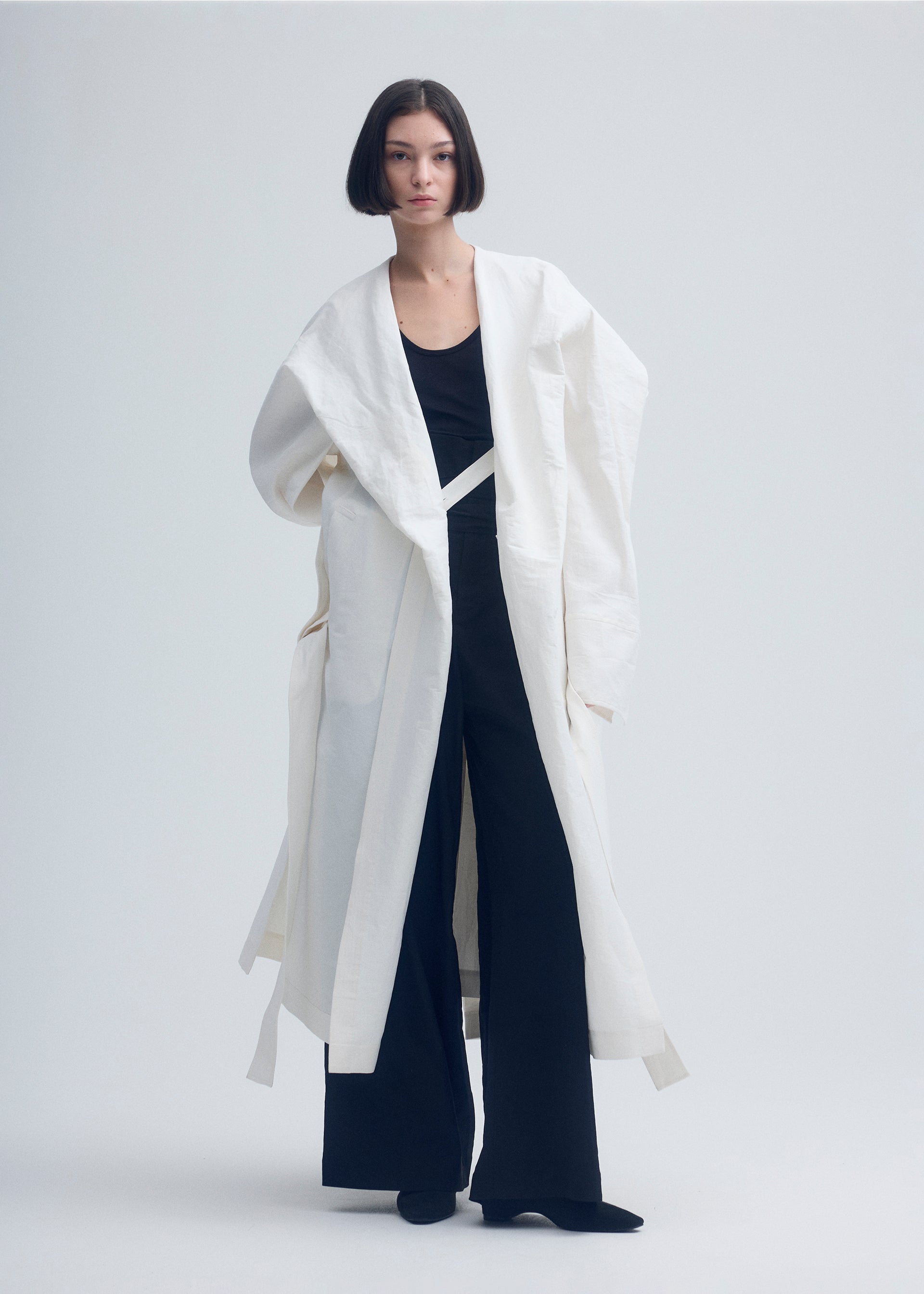 A model wears the ISSEY MIYAKE ENCLOTHE coat