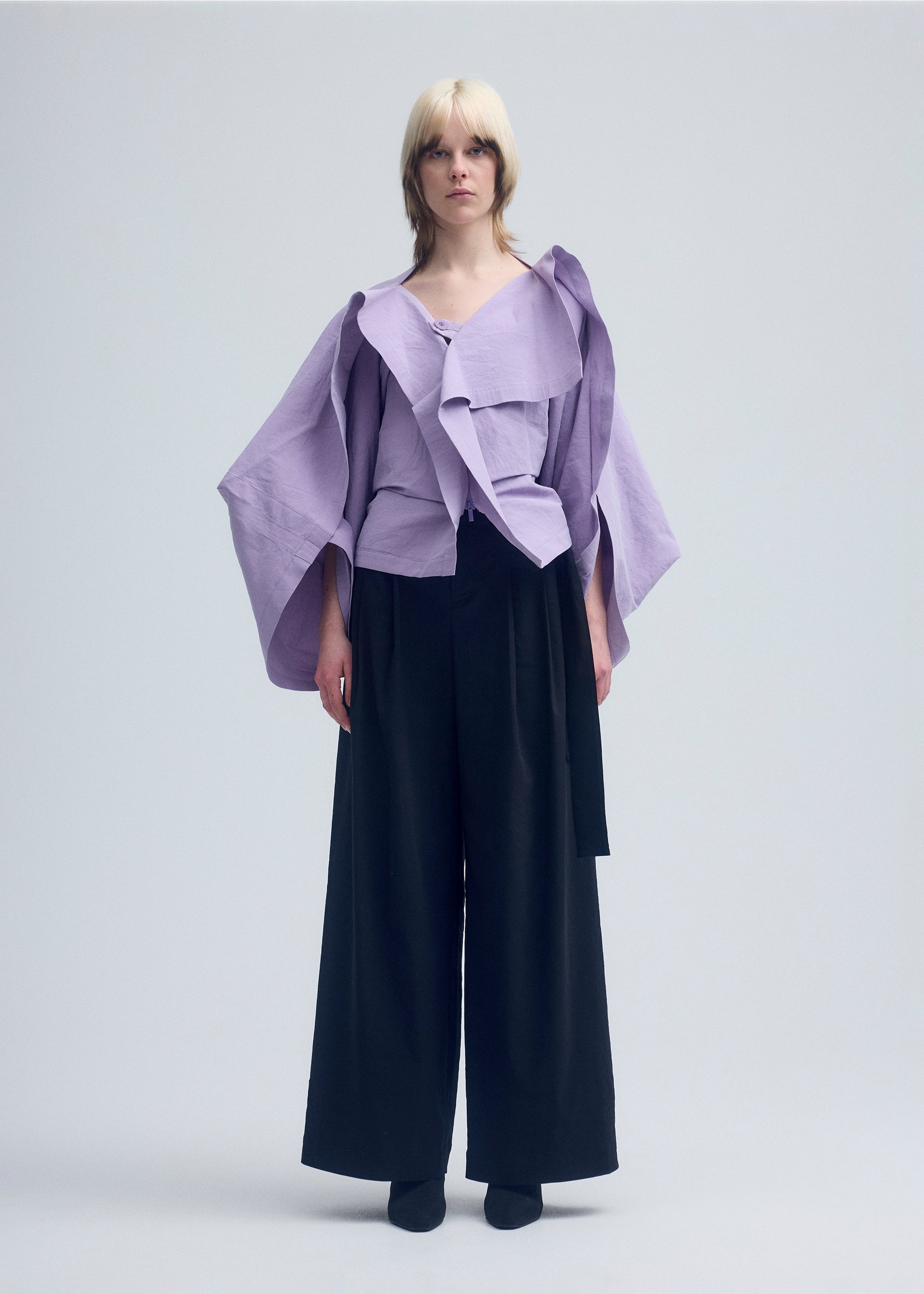 A model wears the ISSEY MIYAKE ENCLOTHE cardigan