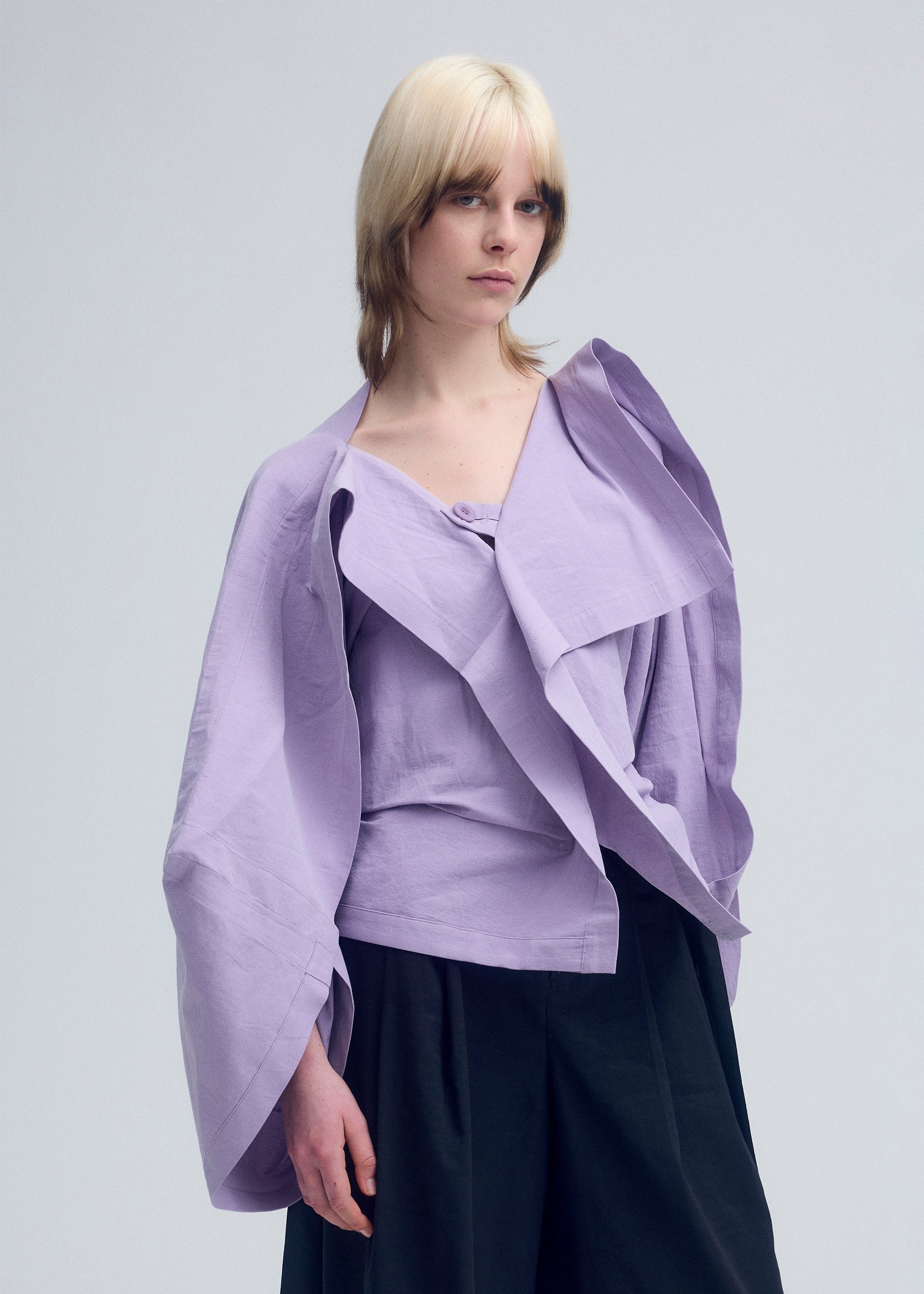 A model wears the ISSEY MIYAKE ENCLOTHE cardigan