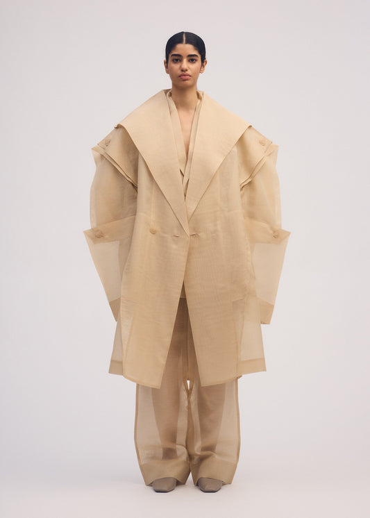 A model wears the ISSEY MIYAKE PRESS AND PRESSED coat.