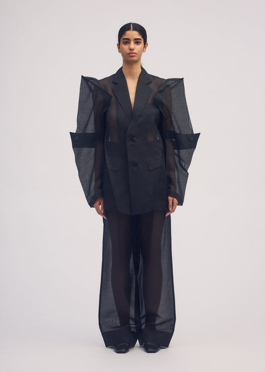 A model wears the ISSEY MIYAKE PRESS AND PRESSED jacket.