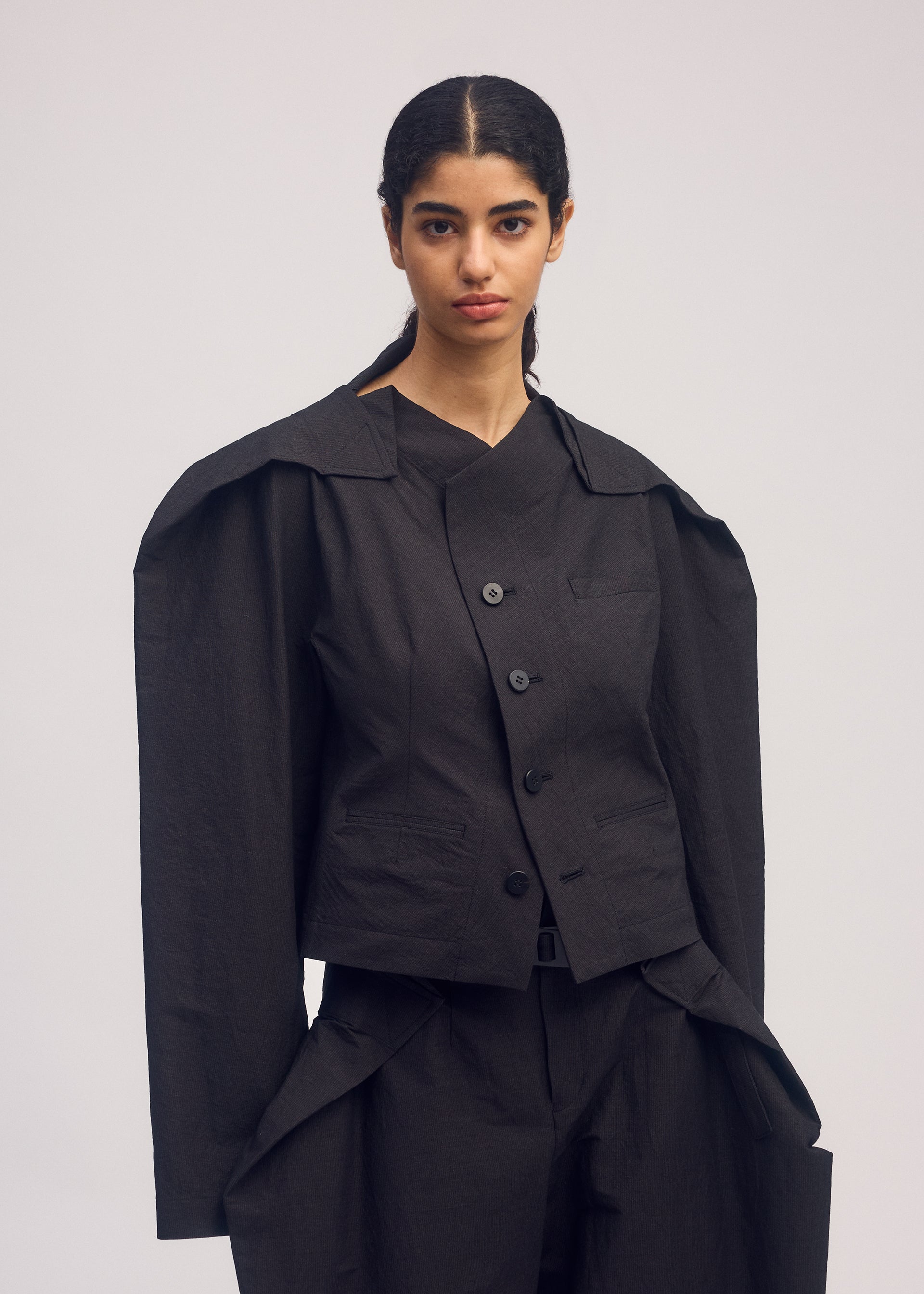 A model wears the ISSEY MIYAKE FOLD TO FORM jacket.