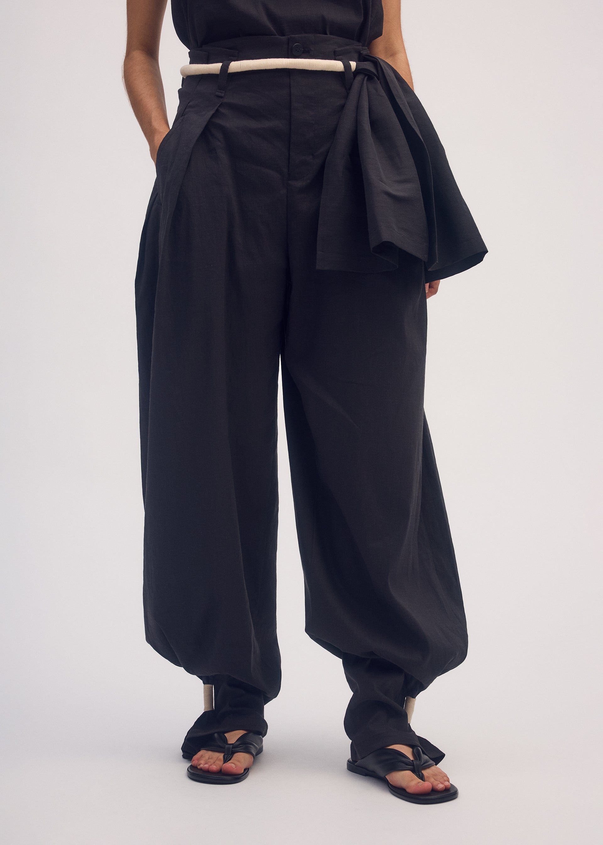 A model wears the ISSEY MIYAKE CLOTH AND CORD trousers.