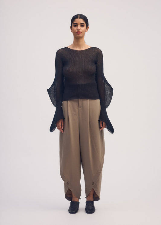 A model wears the ISSEY MIYAKE ROUND PANTS trousers.