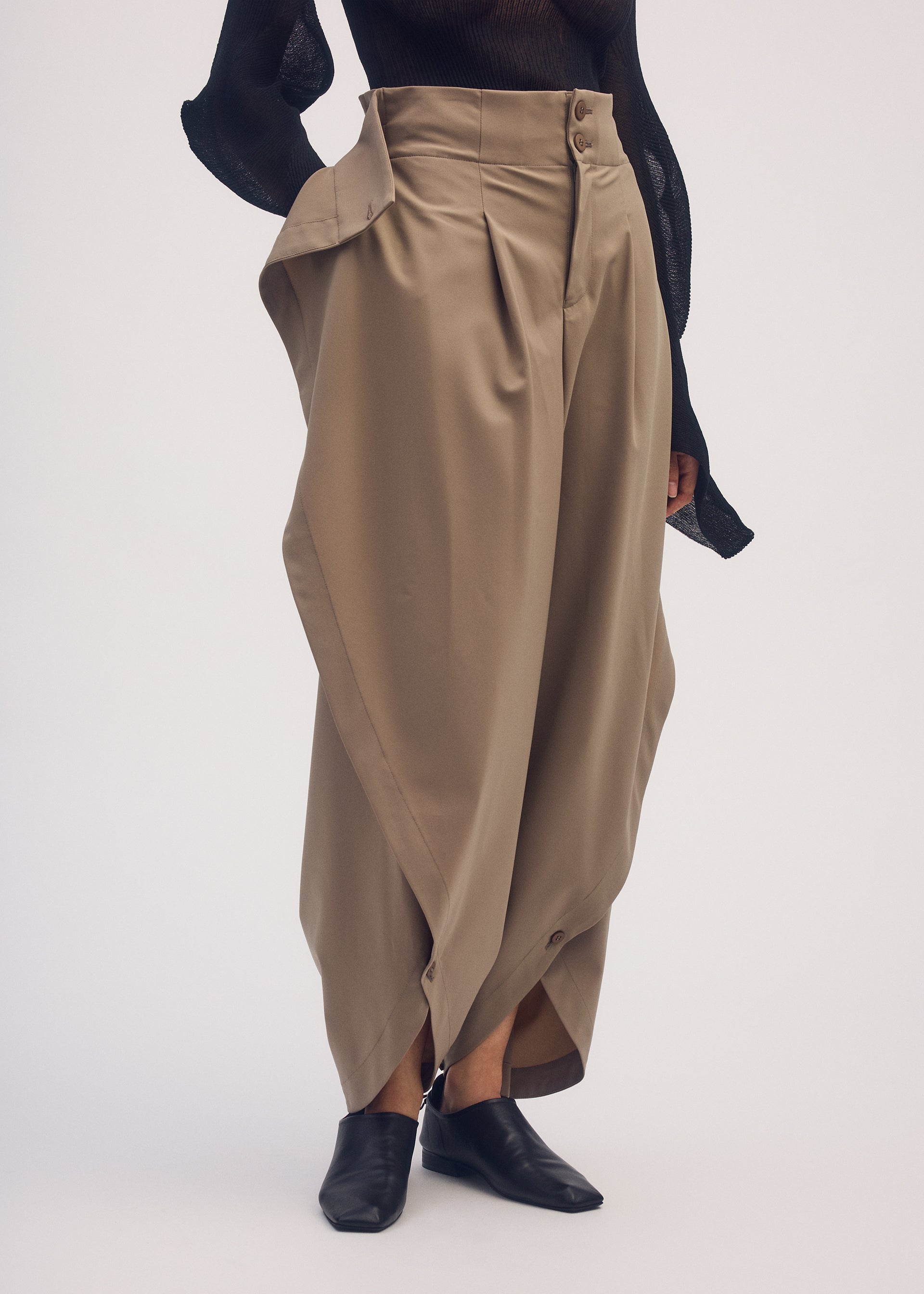 A model wears the ISSEY MIYAKE ROUND PANTS trousers.