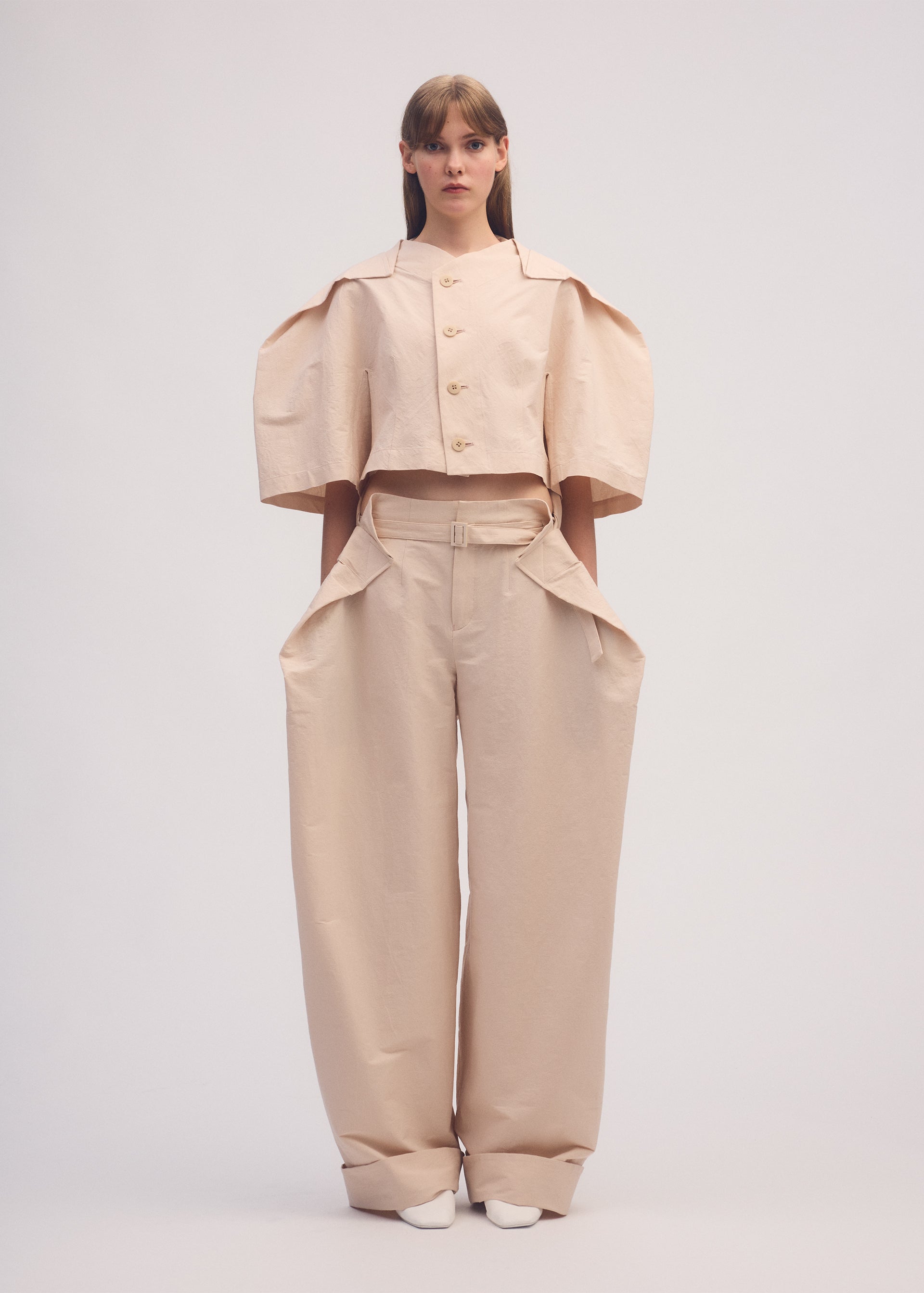 A model wears the ISSEY MIYAKE FOLD TO FORM trousers.