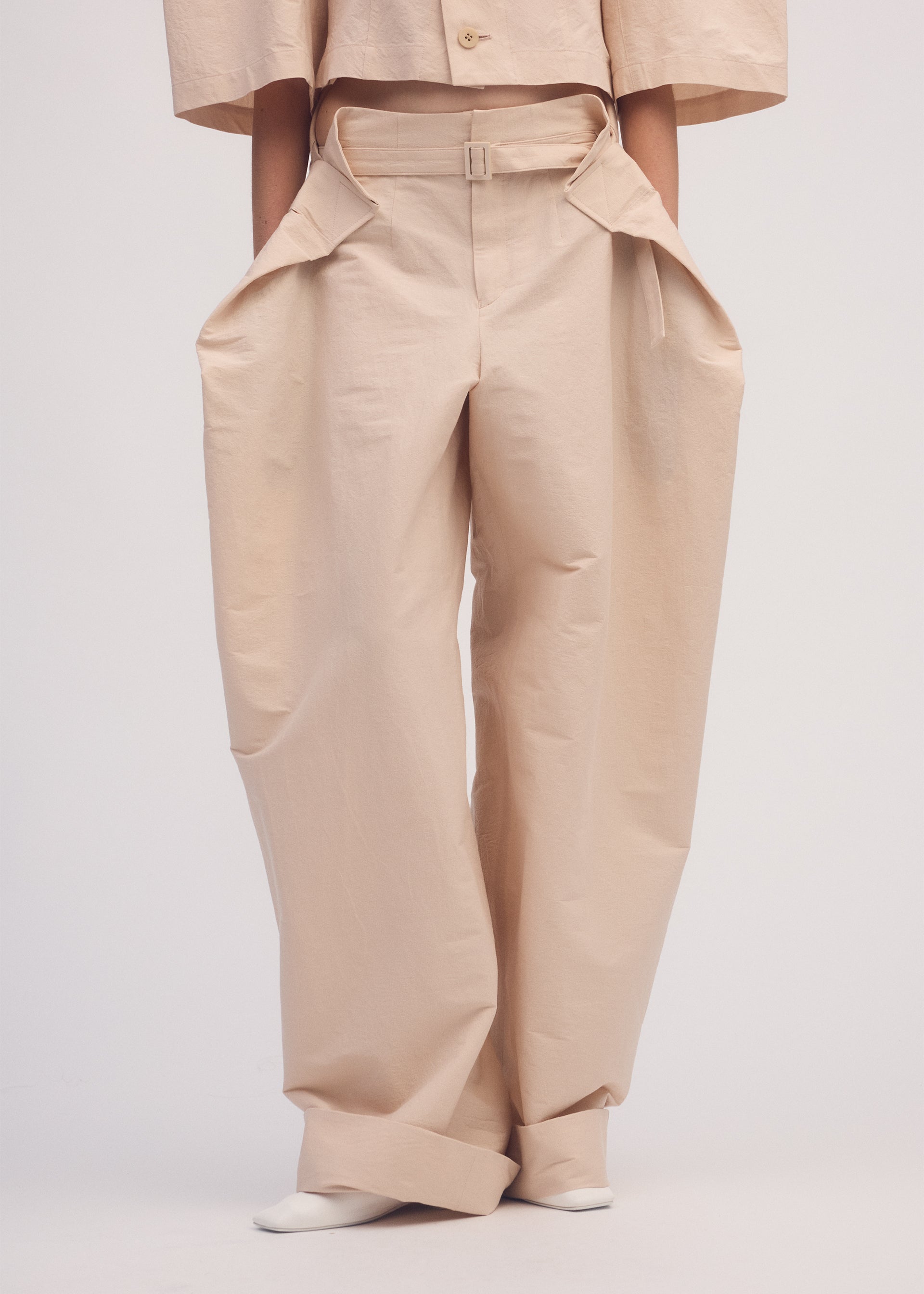 A model wears the ISSEY MIYAKE FOLD TO FORM trousers.