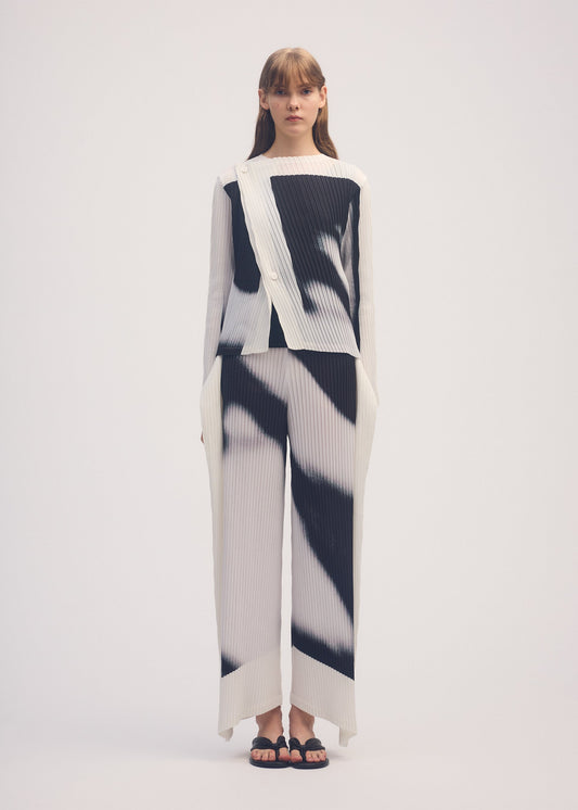 A model wears the ISSEY MIYAKE SHADOW STUDY PLEATS trousers.