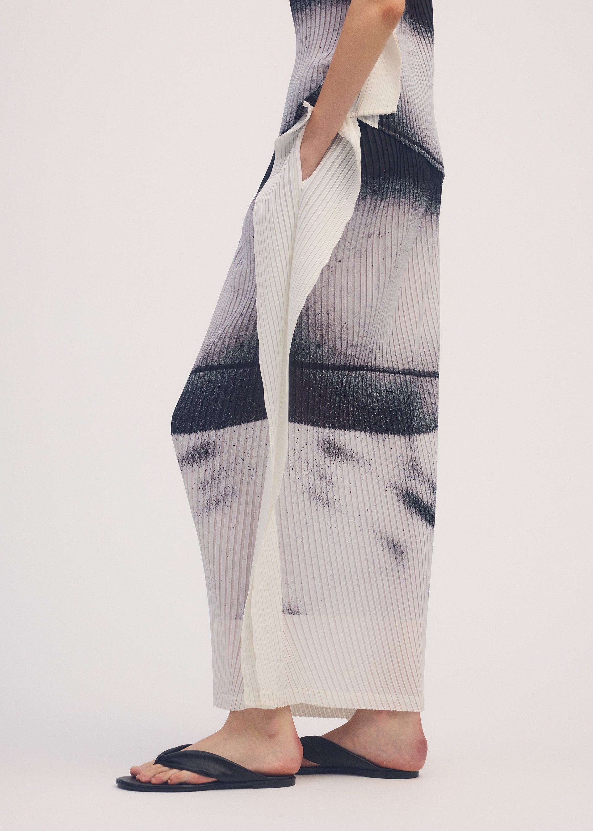A model wears the ISSEY MIYAKE SHADOW STUDY PLEATS skirt.