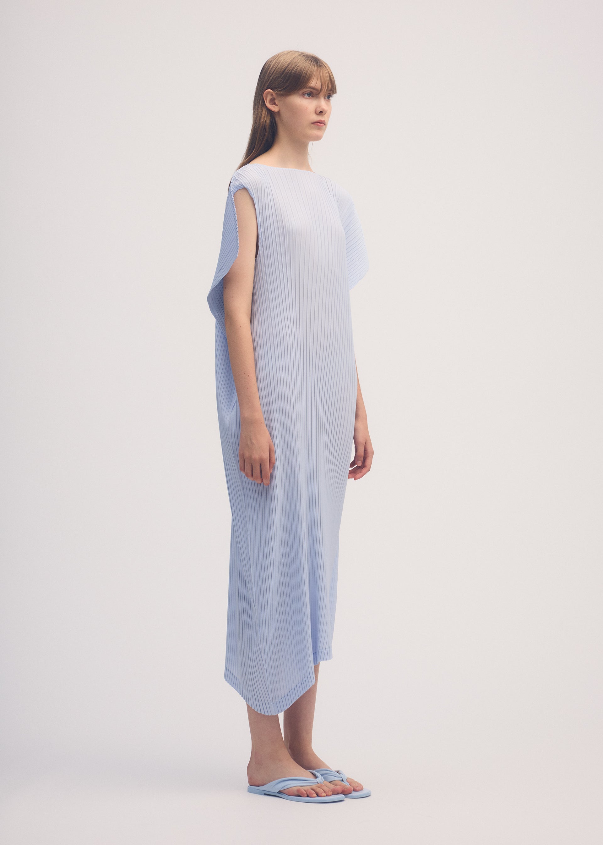 A model wears the ISSEY MIYAKE SHADOW STUDY PLEATS SOLID dress.