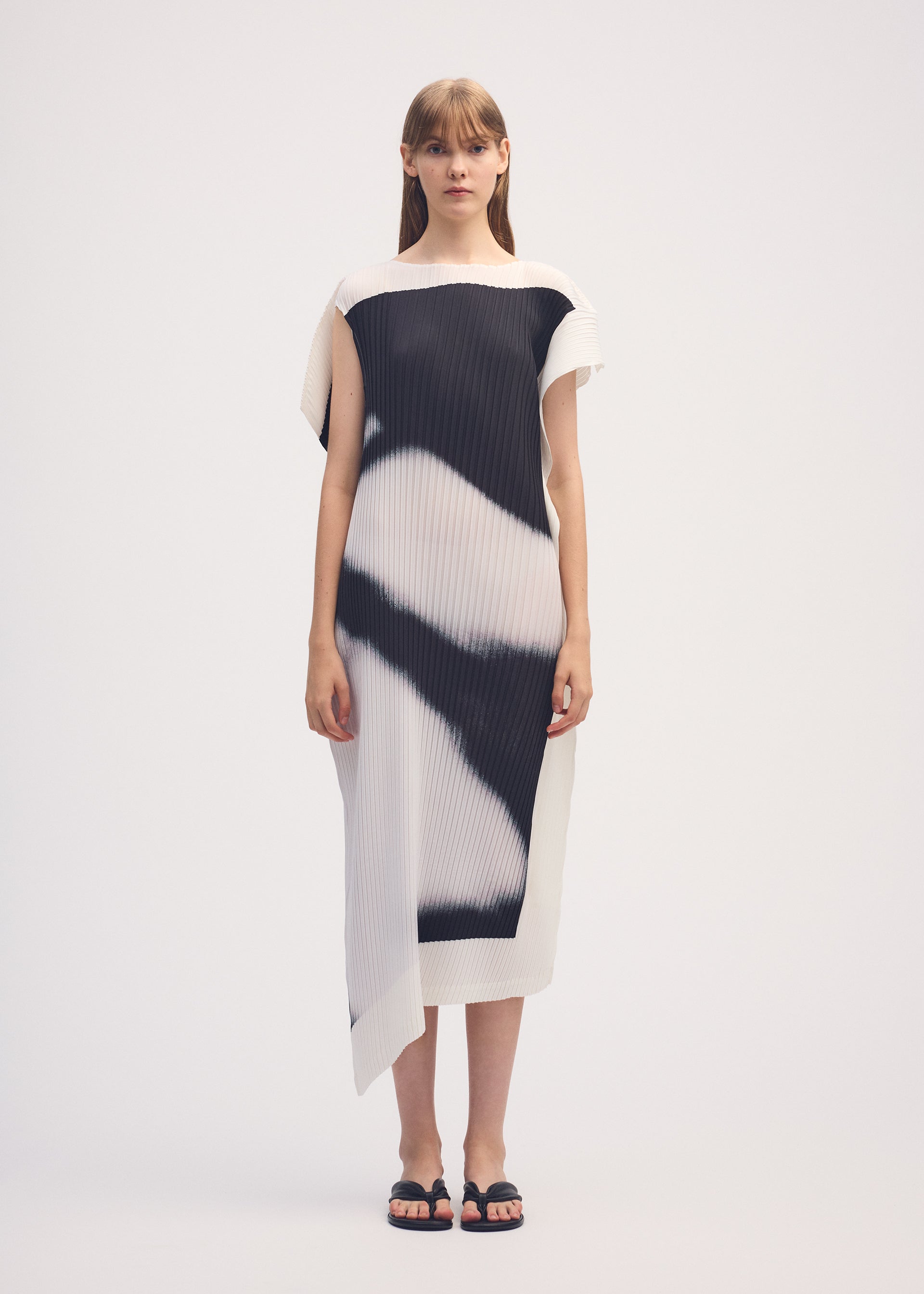 A model wears the ISSEY MIYAKE SHADOW STUDY PLEATS dress.
