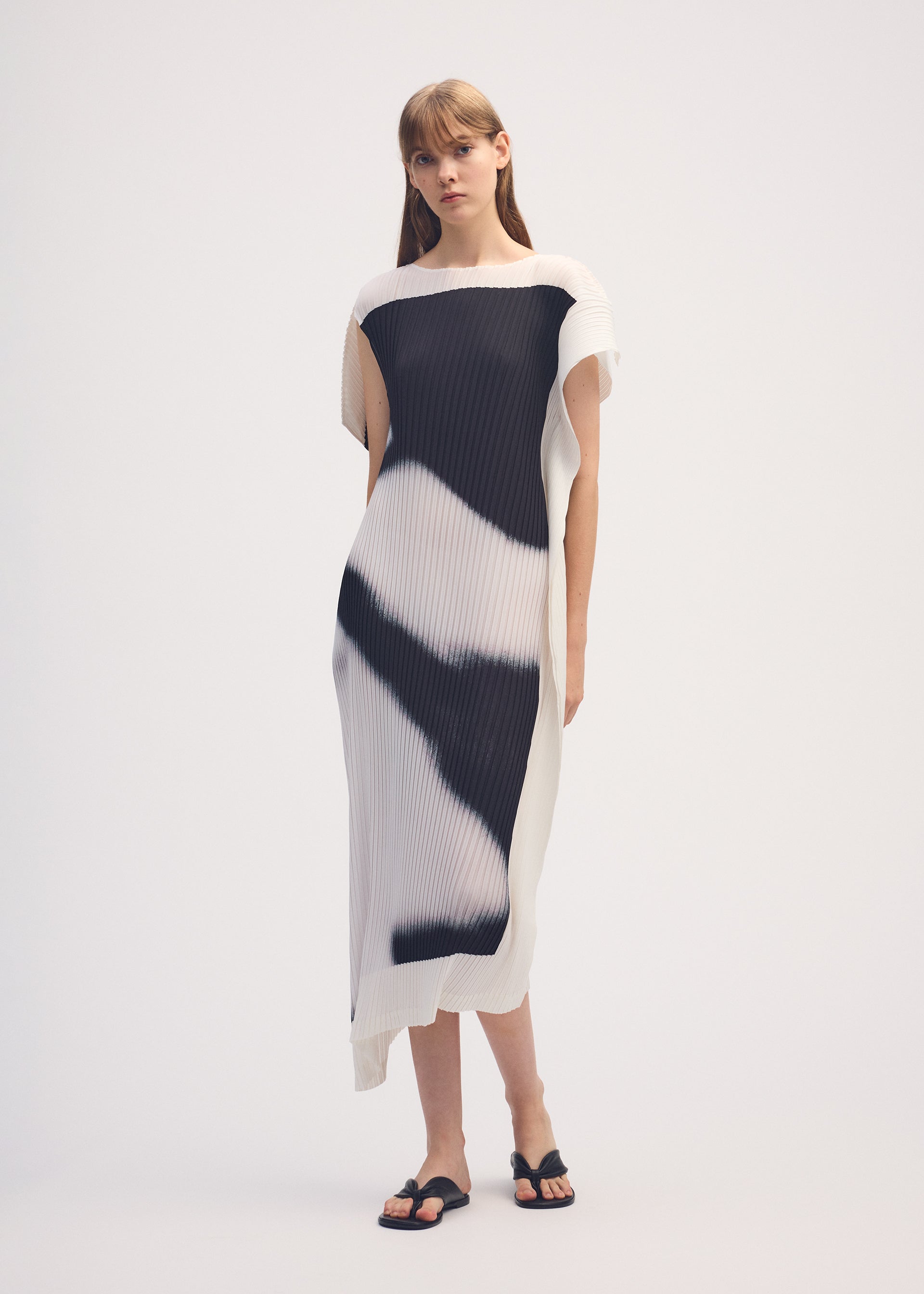 A model wears the ISSEY MIYAKE SHADOW STUDY PLEATS dress.