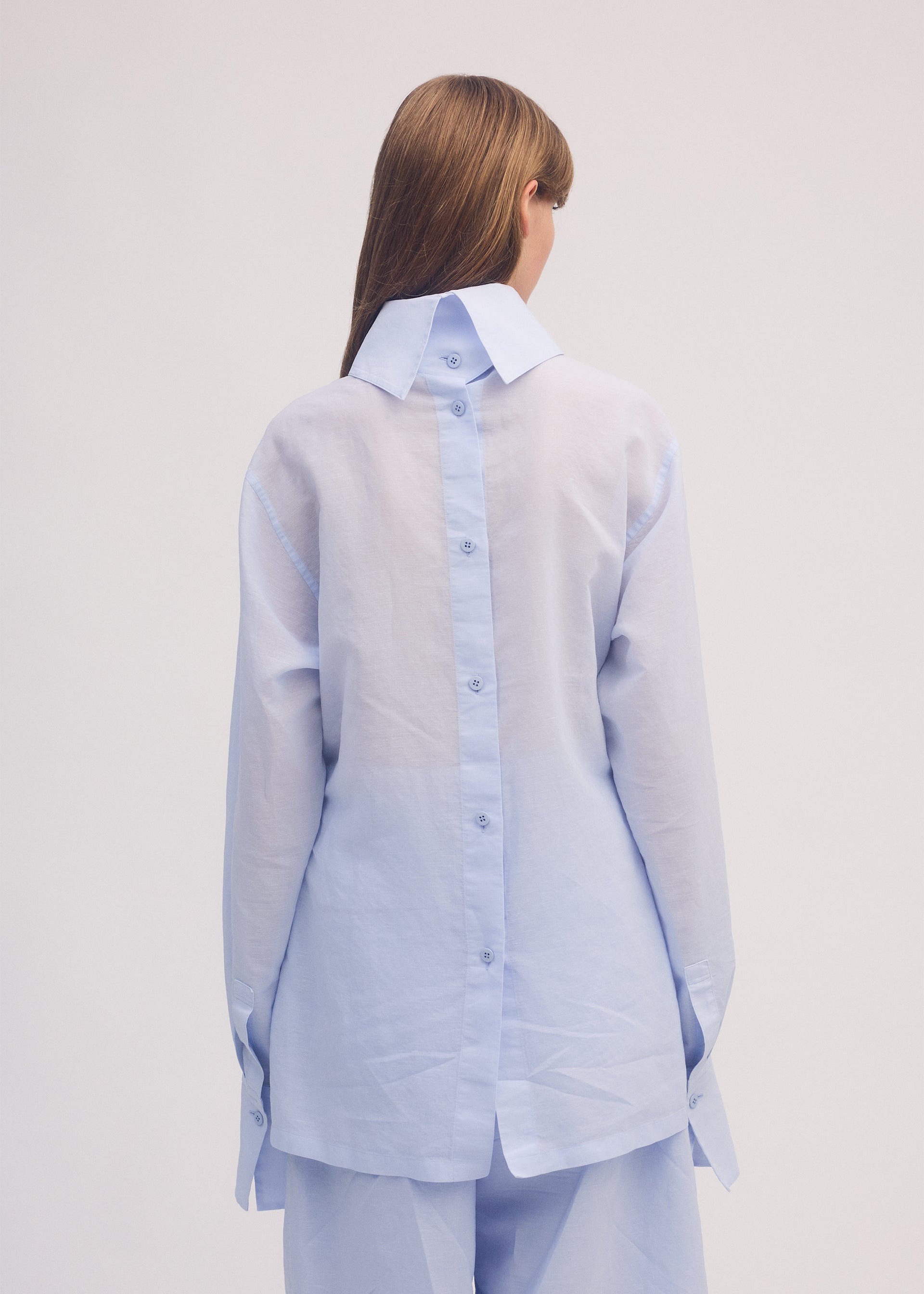 A model wears the ISSEY MIYAKE PAPER ESQUE U shirt.