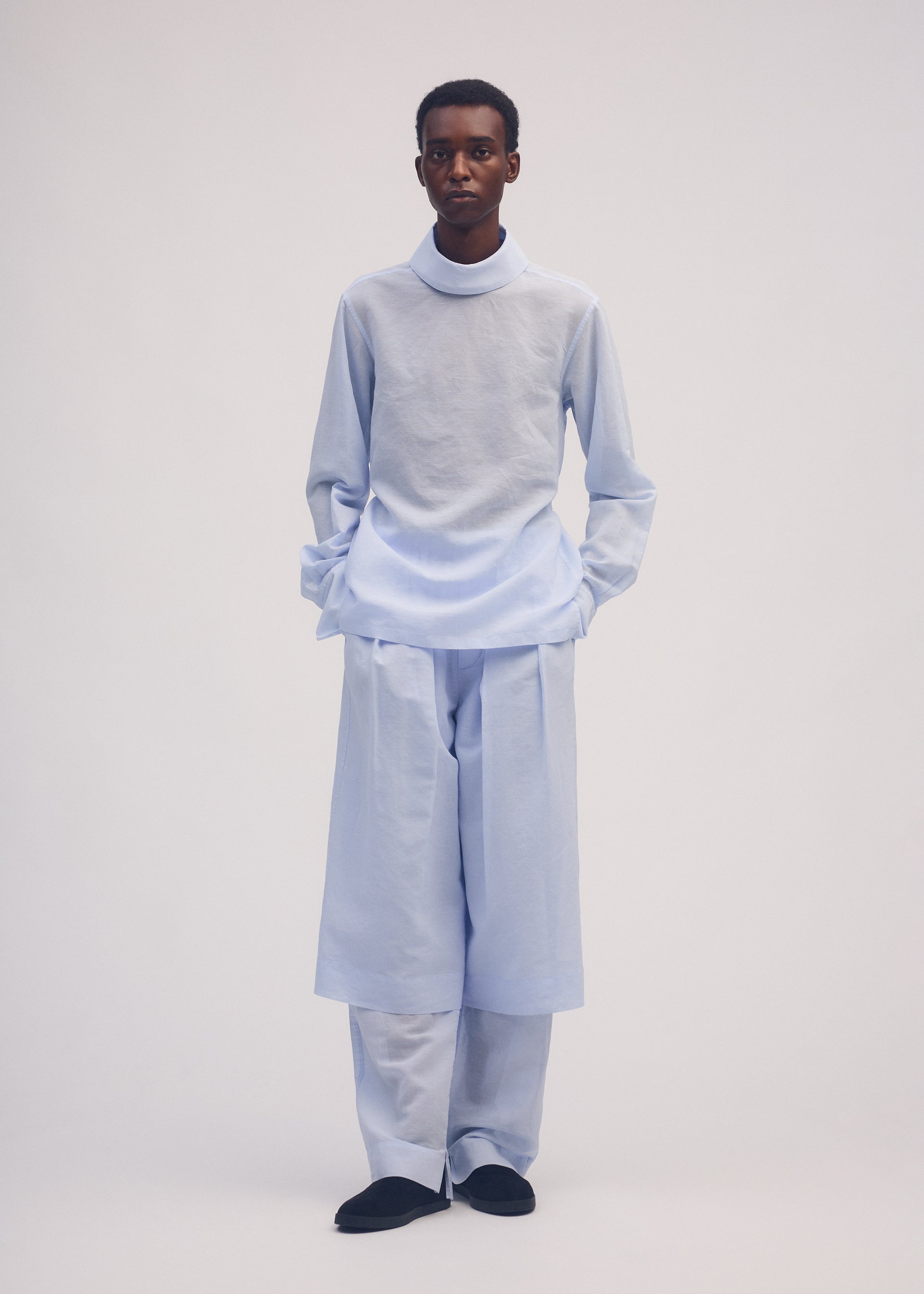 A model wears the ISSEY MIYAKE PAPER ESQUE U shirt.