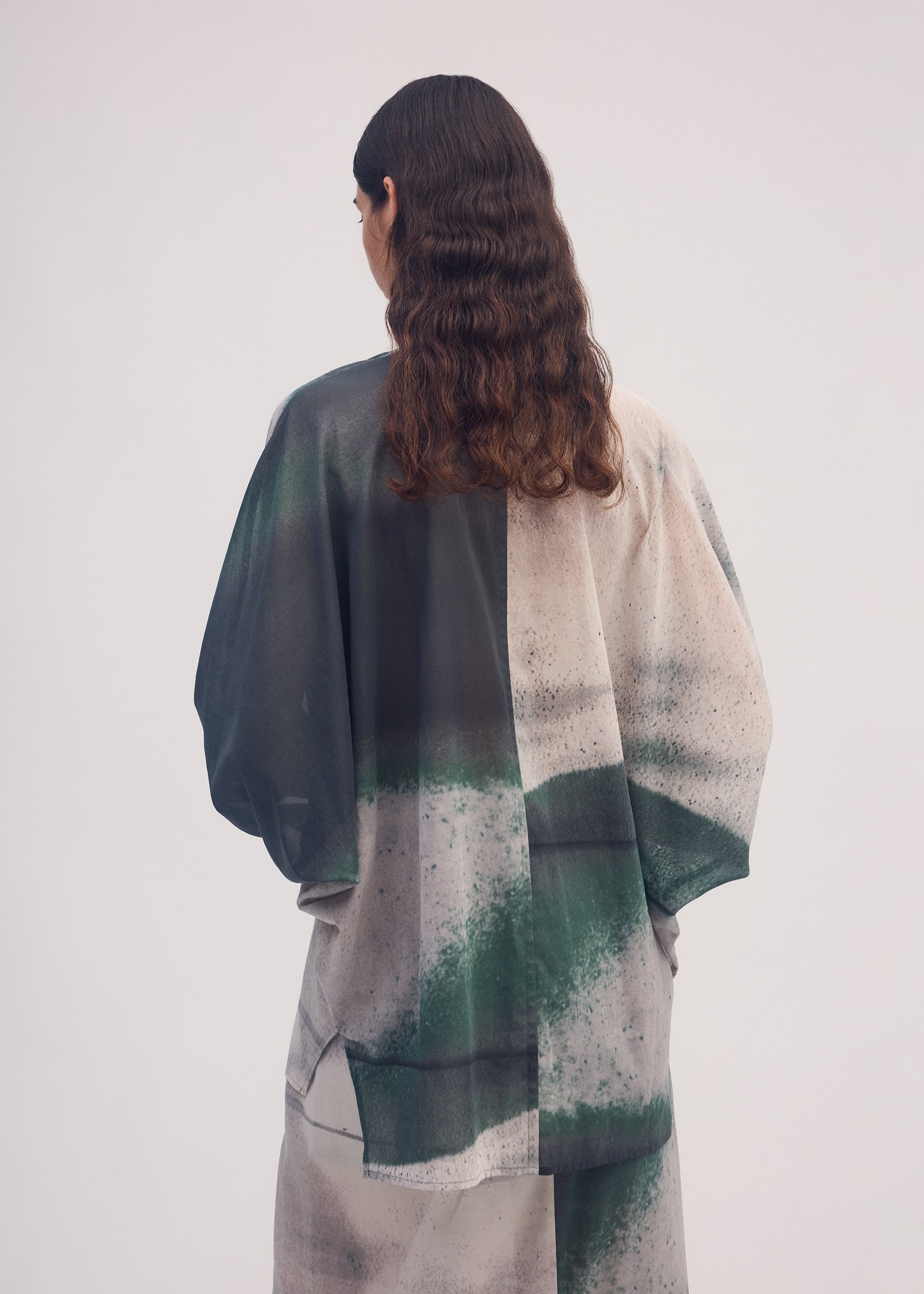A model wears the ISSEY MIYAKE SHADOW STUDY shirt.