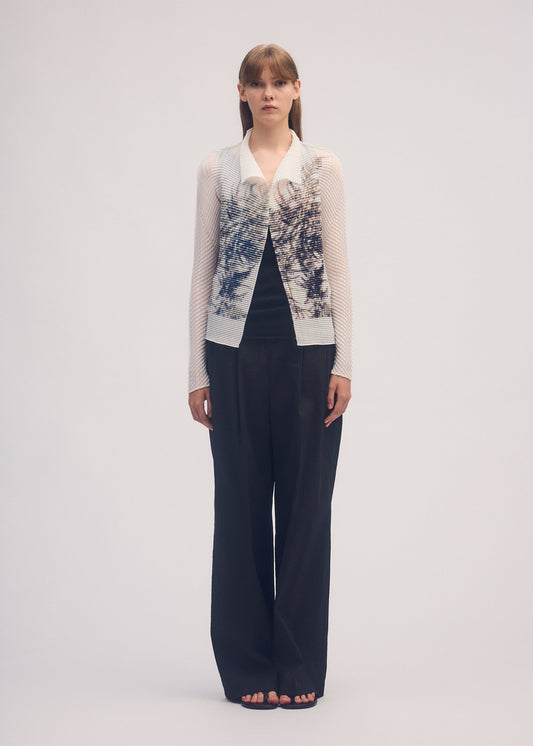A model wears the ISSEY MIYAKE PRESSED FLORA PLEATS TOP shirt.