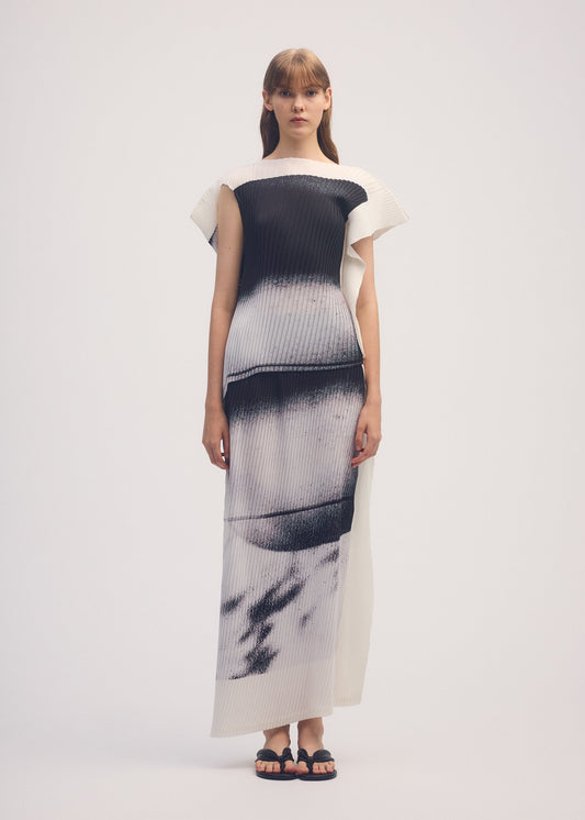 A model wears the ISSEY MIYAKE SHADOW STUDY PLEATS shirt.