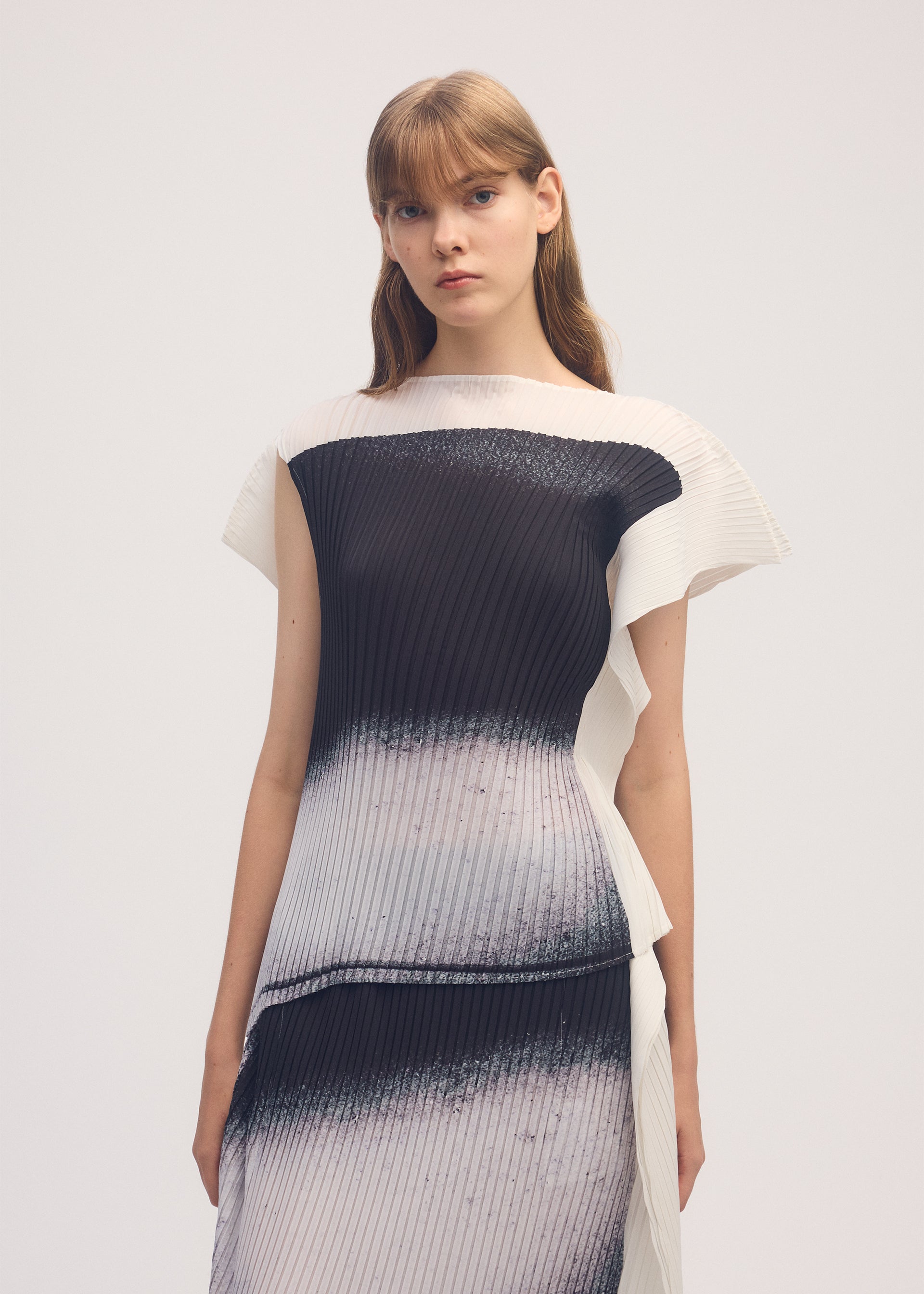 A model wears the ISSEY MIYAKE SHADOW STUDY PLEATS shirt.