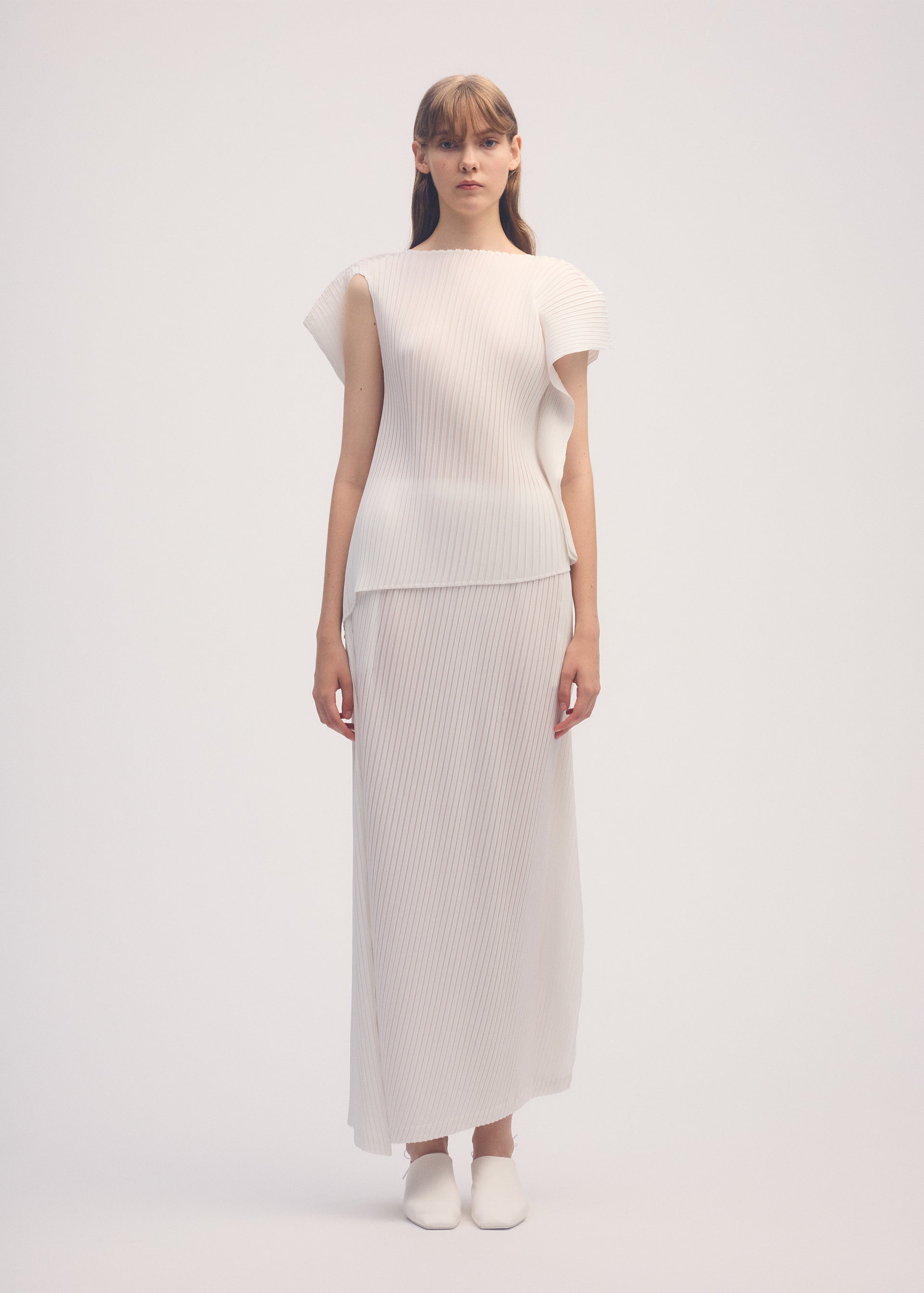 A model wears the ISSEY MIYAKE SHADOW STUDY PLEATS SOLID shirt.