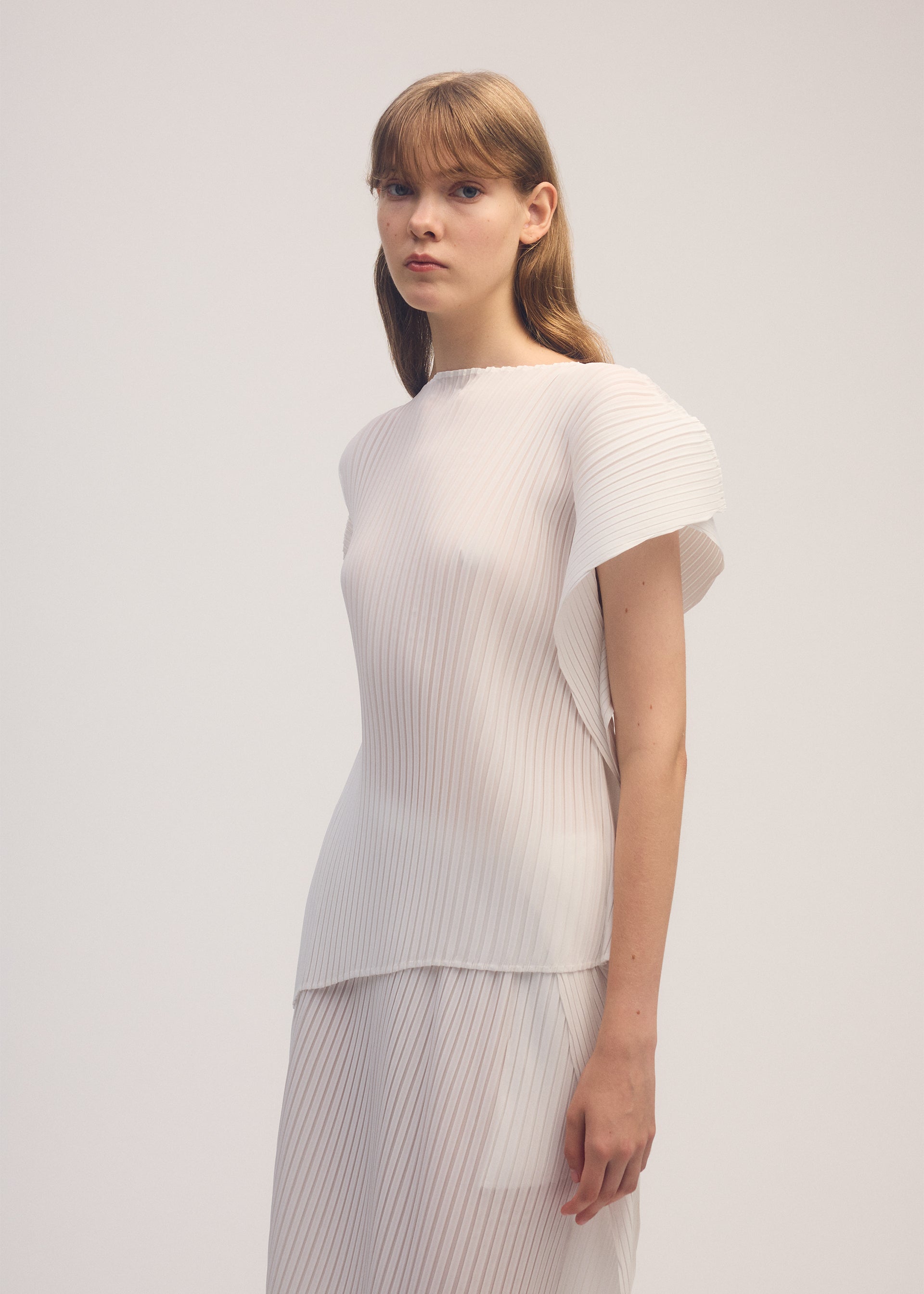 A model wears the ISSEY MIYAKE SHADOW STUDY PLEATS SOLID shirt.