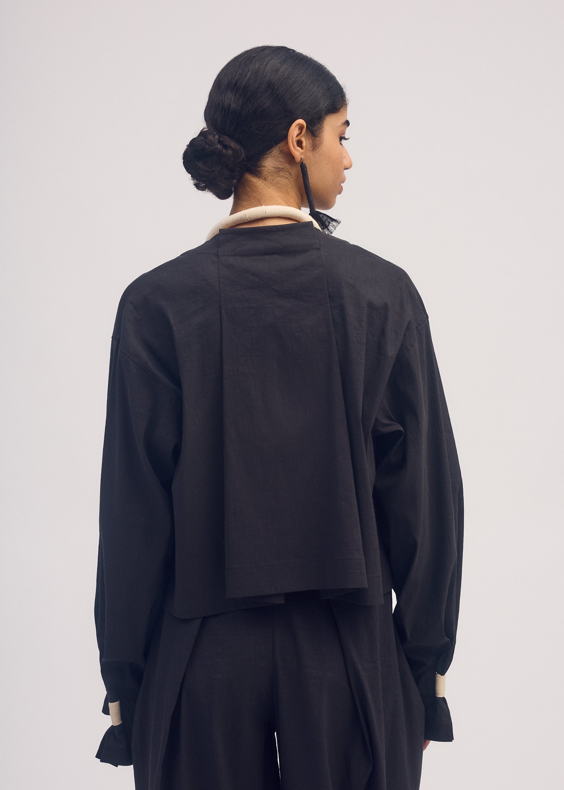 A model wears the ISSEY MIYAKE CLOTH AND CORD cardigan.