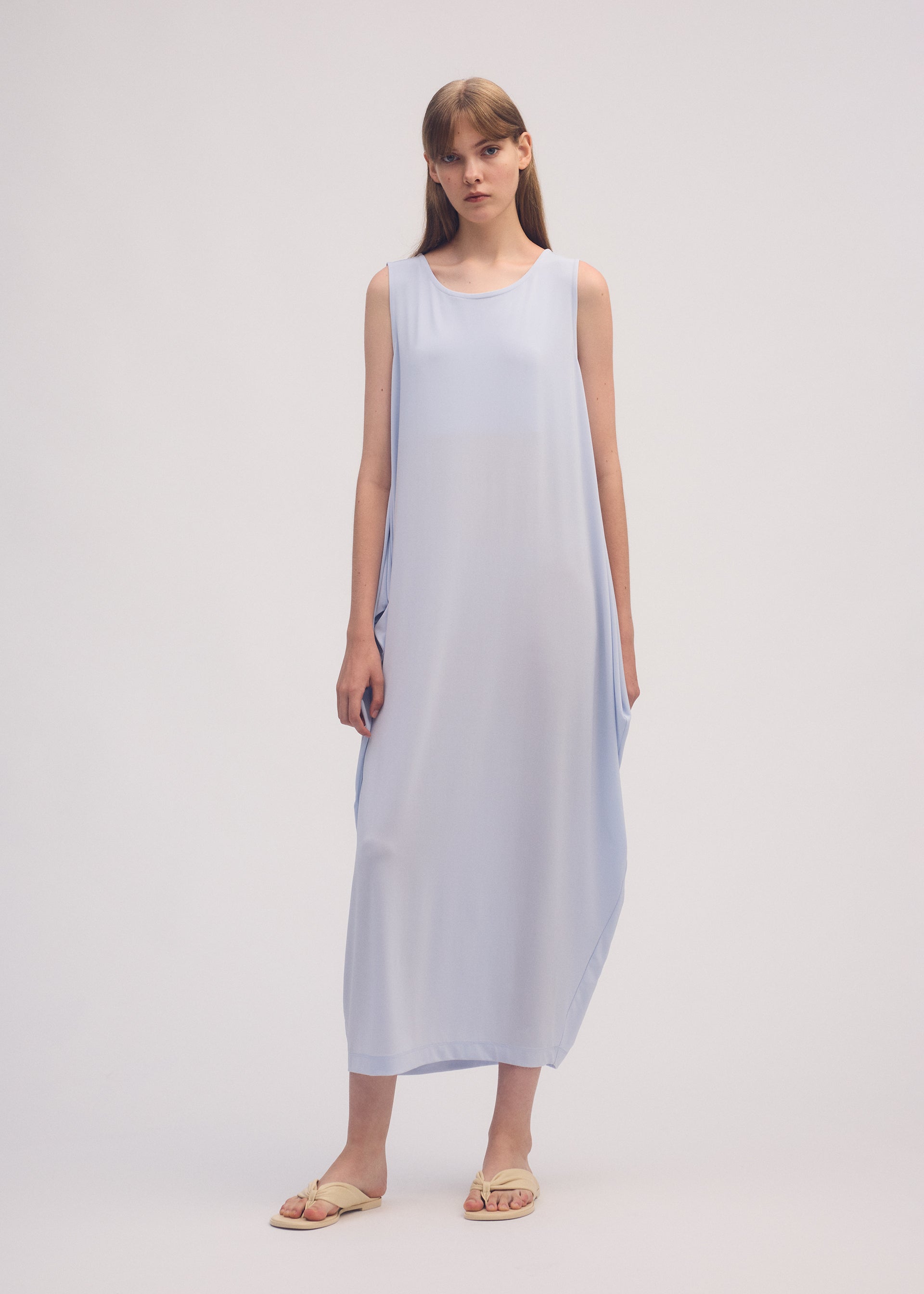 A model wears the ISSEY MIYAKE DRAPE JERSEY 56 dress.