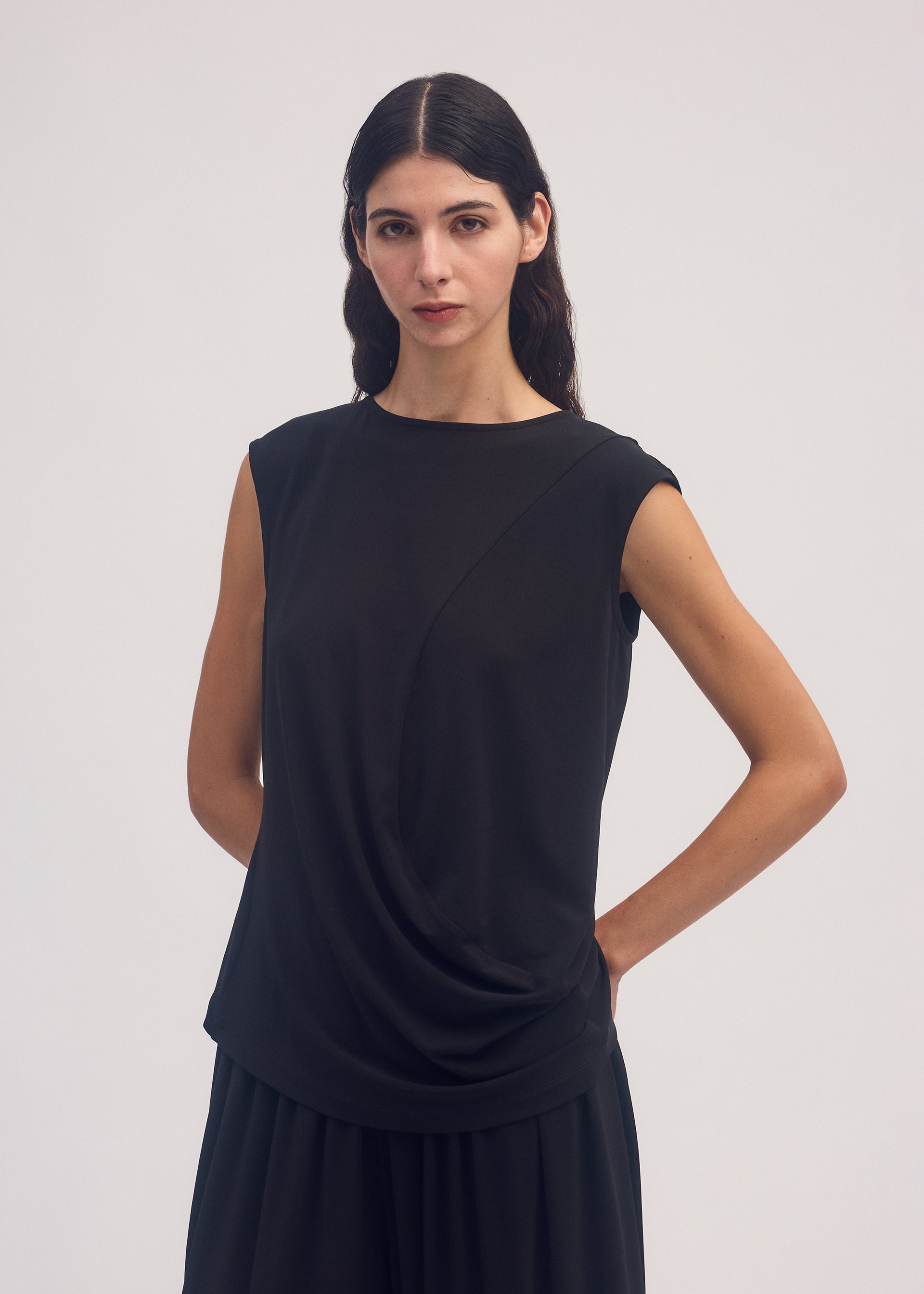 A model wears the ISSEY MIYAKE DRAPE JERSEY 56 top.