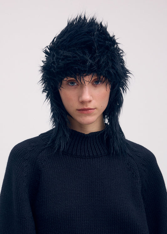 A model wears the ISSEY MIYAKE ODD BEANIE hat.