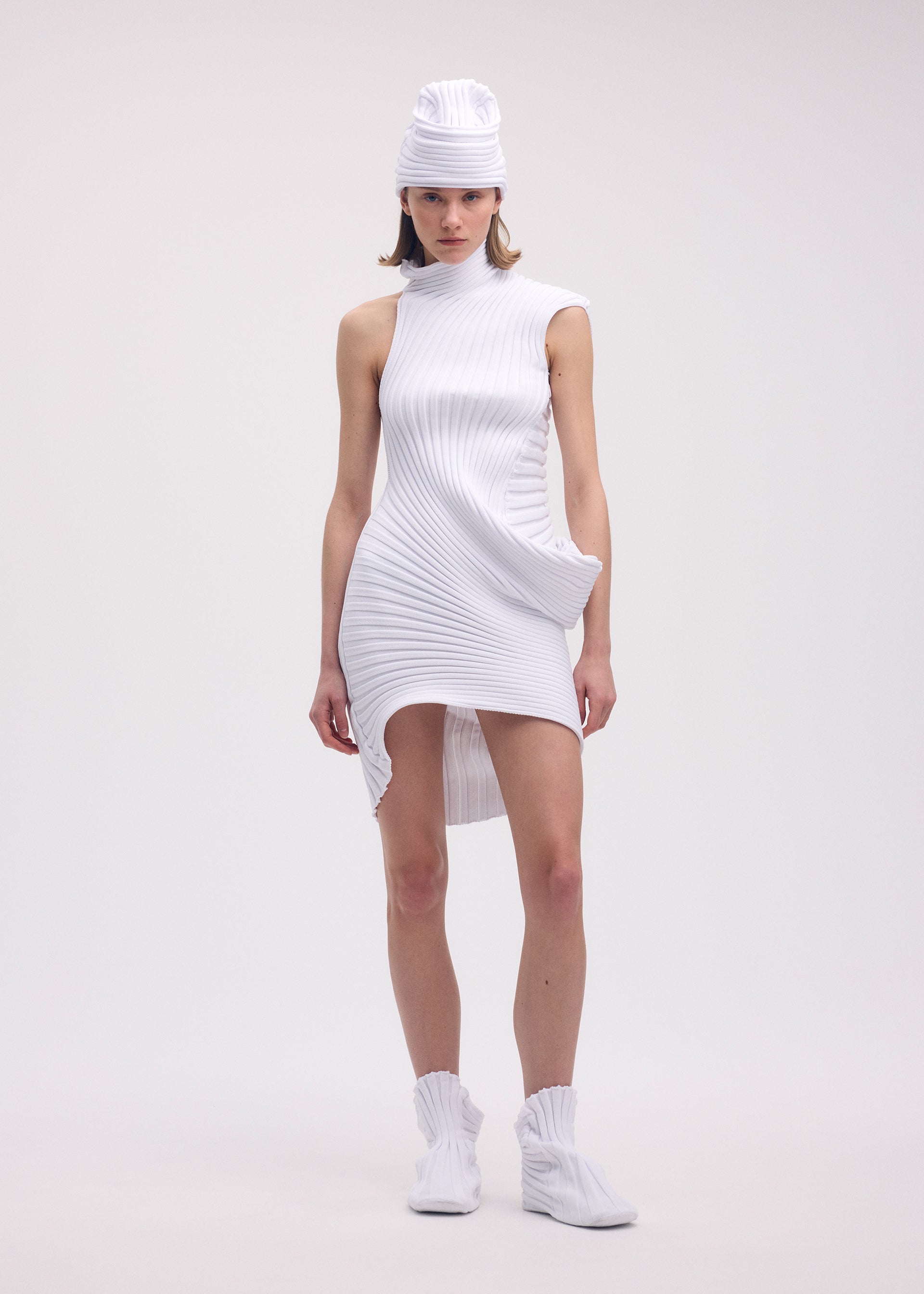 A model wears the ISSEY MIYAKE KNIT (AS IT IS) ACC hat.