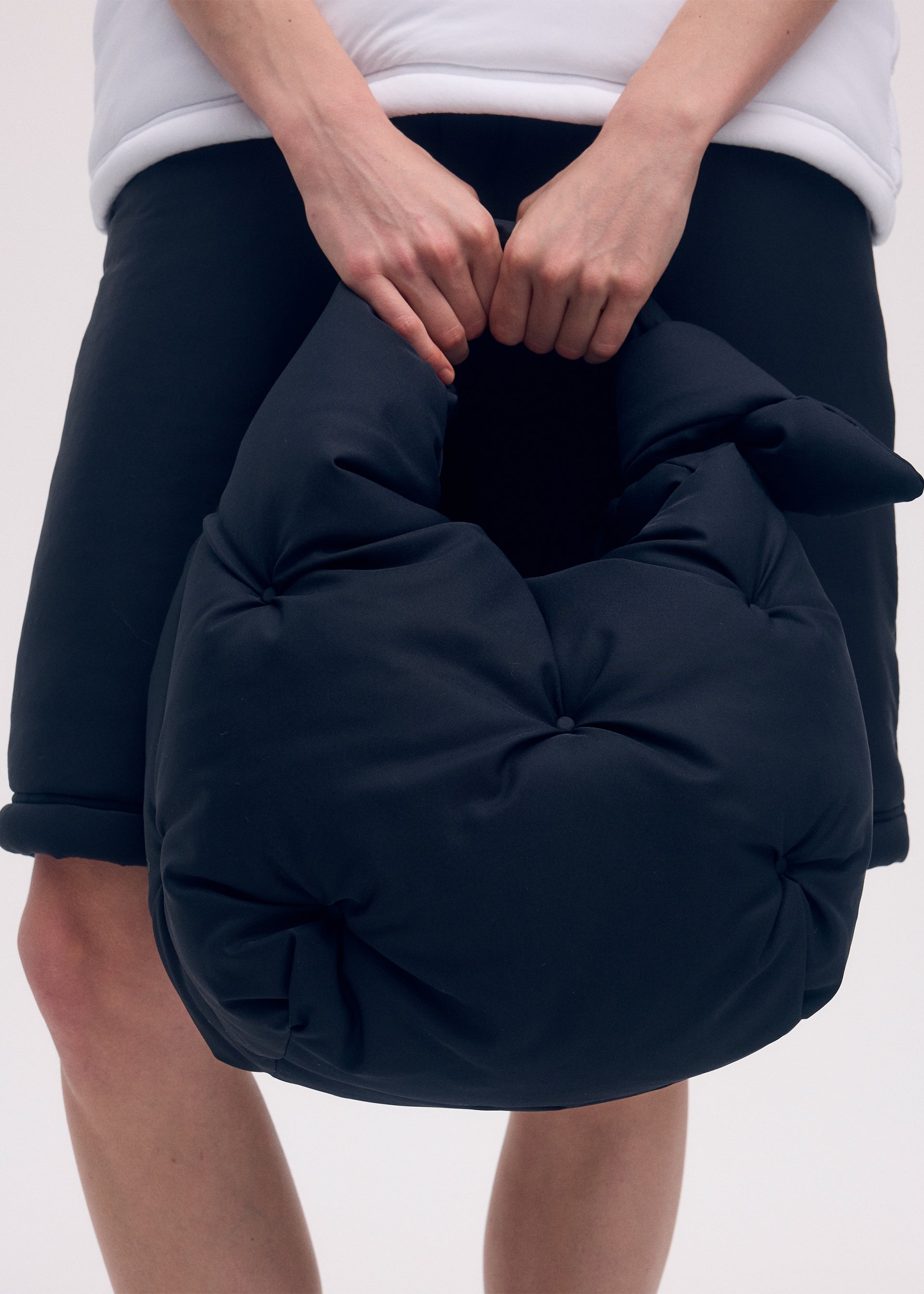 A model wears the ISSEY MIYAKE PUMPED BAG bag.