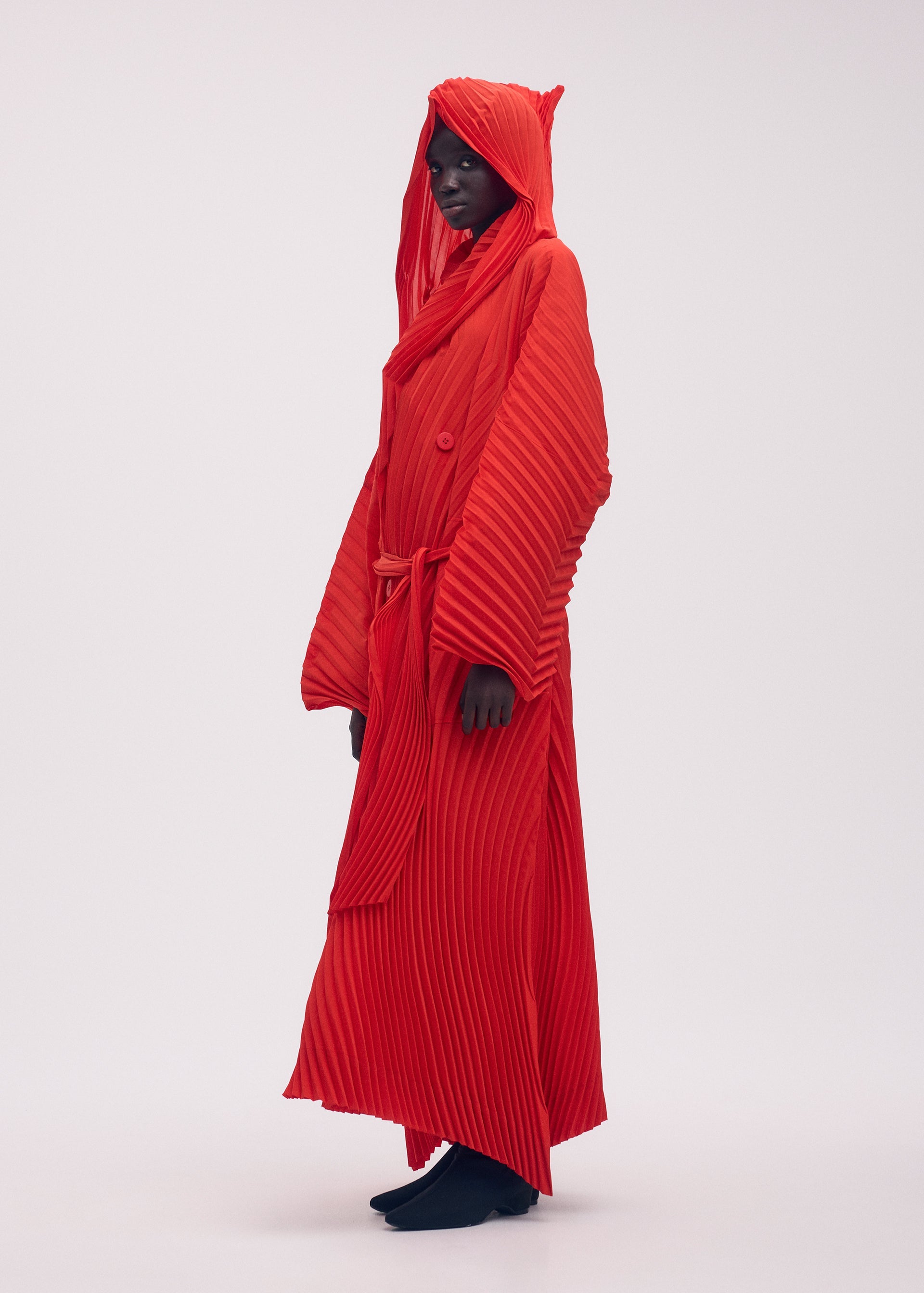 A model wears the ISSEY MIYAKE WAVE PLEATS coat.