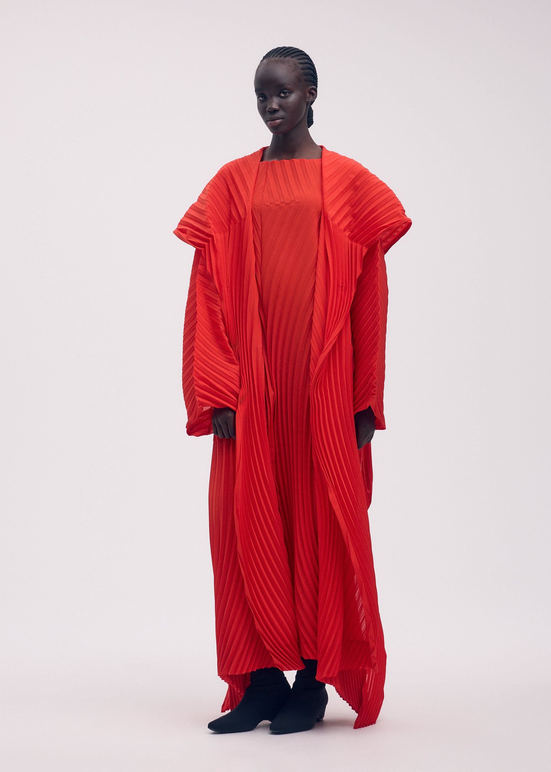 A model wears the ISSEY MIYAKE WAVE PLEATS coat.