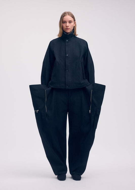 A model wears the ISSEY MIYAKE PEEKABOO jacket.