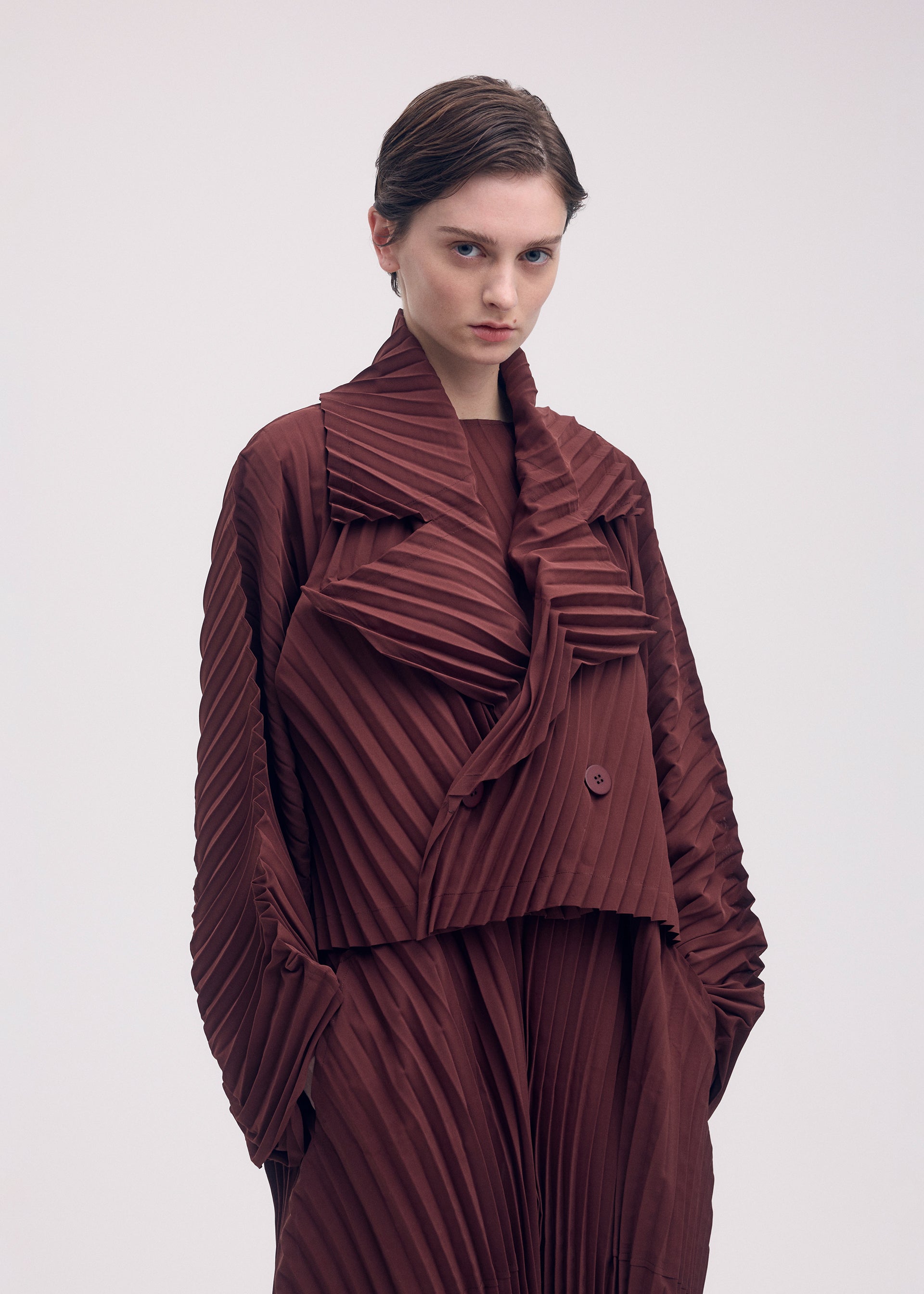 A model wears the ISSEY MIYAKE WAVE PLEATS jacket.
