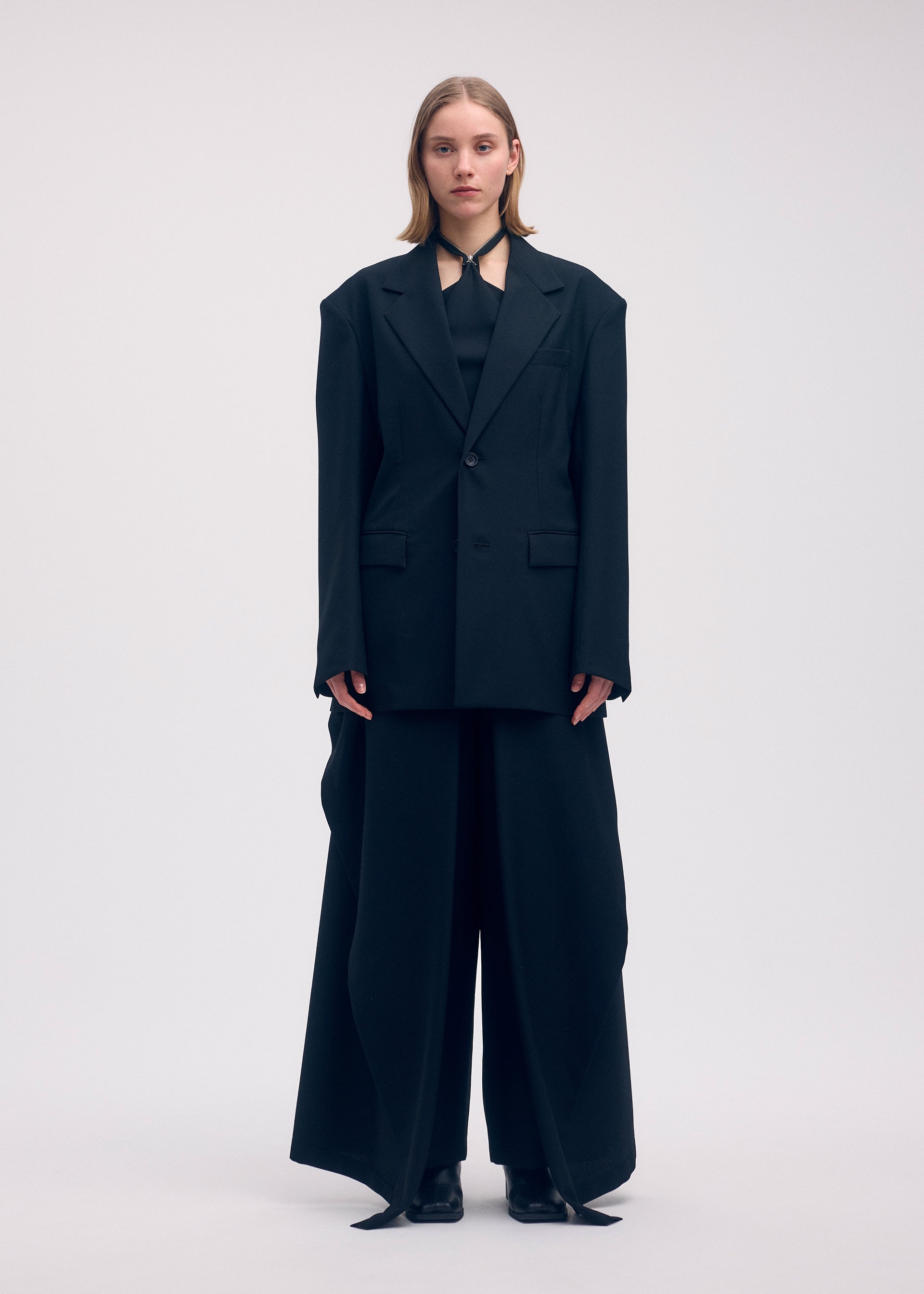A model wears the ISSEY MIYAKE UNI FORM (WOOL) trousers.