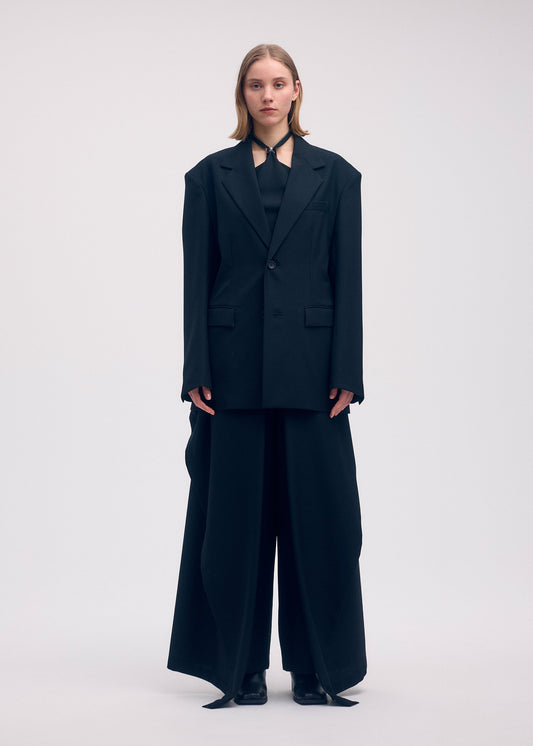 A model wears the ISSEY MIYAKE UNI FORM (WOOL) trousers.