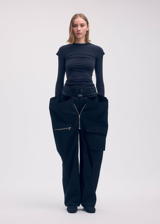 A model wears the ISSEY MIYAKE PEEKABOO trousers.