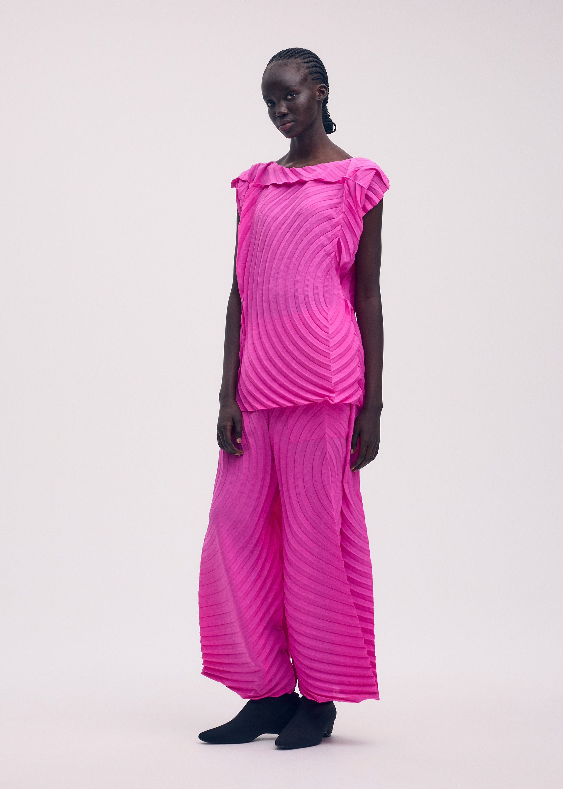 A model wears the ISSEY MIYAKE PAPER BAG PLEATS trousers.