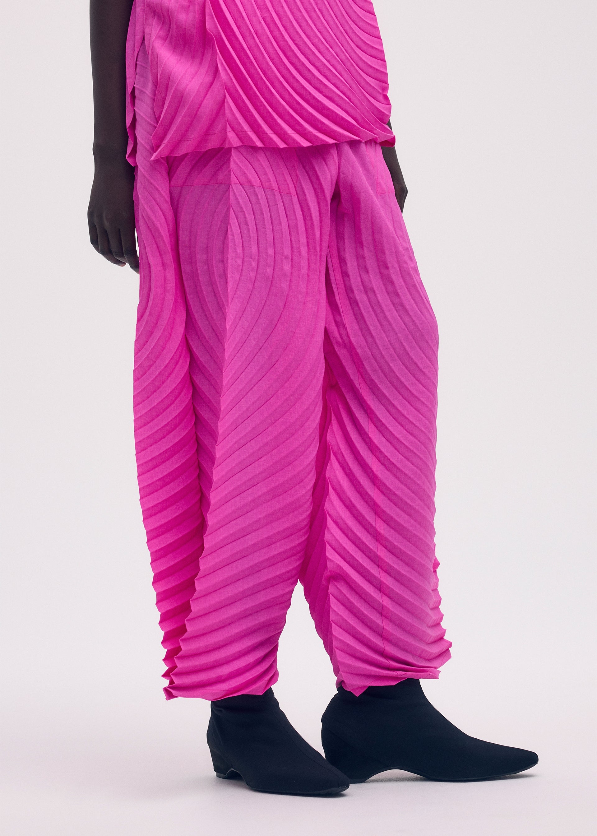 A model wears the ISSEY MIYAKE PAPER BAG PLEATS trousers.