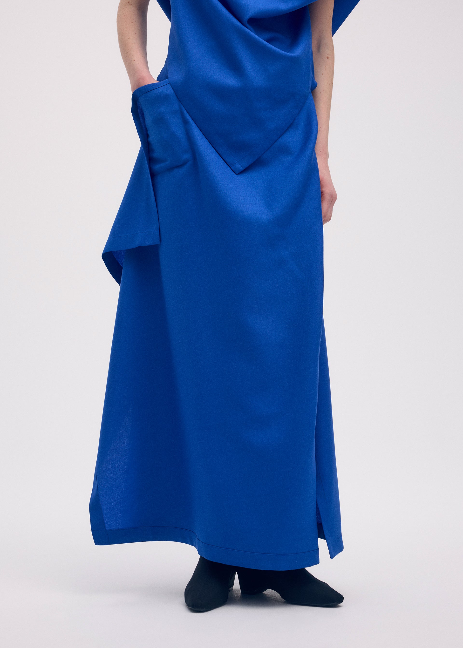 A model wears the ISSEY MIYAKE UNI FORM (WOOL) skirt.