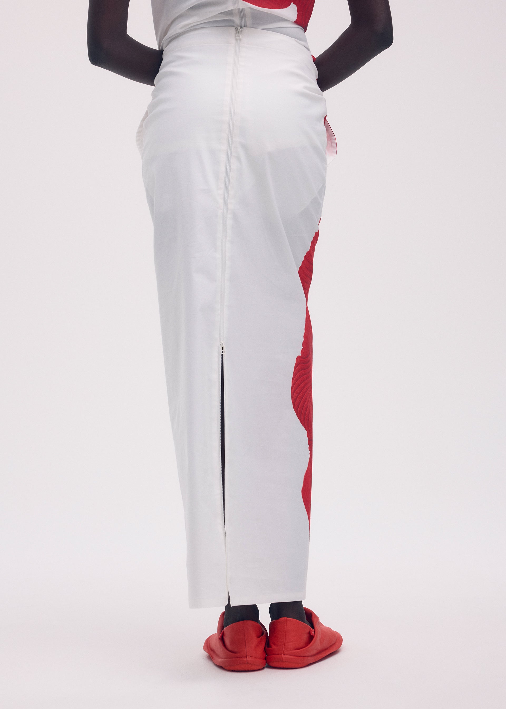 A model wears the ISSEY MIYAKE KNIT (AS REPRESENTED) skirt.
