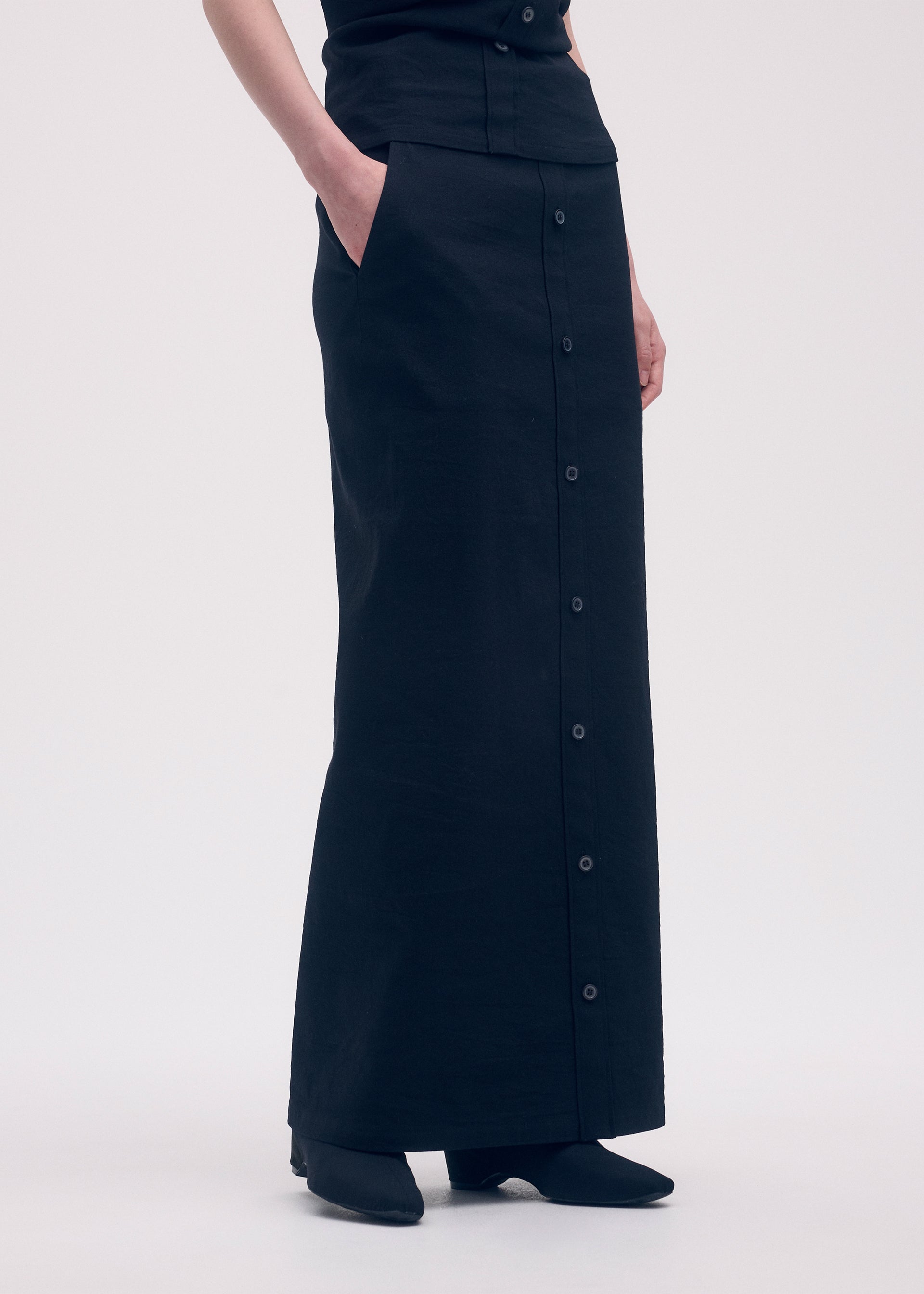 A model wears the ISSEY MIYAKE LIKE TORSO LIKE SHIRT skirt.