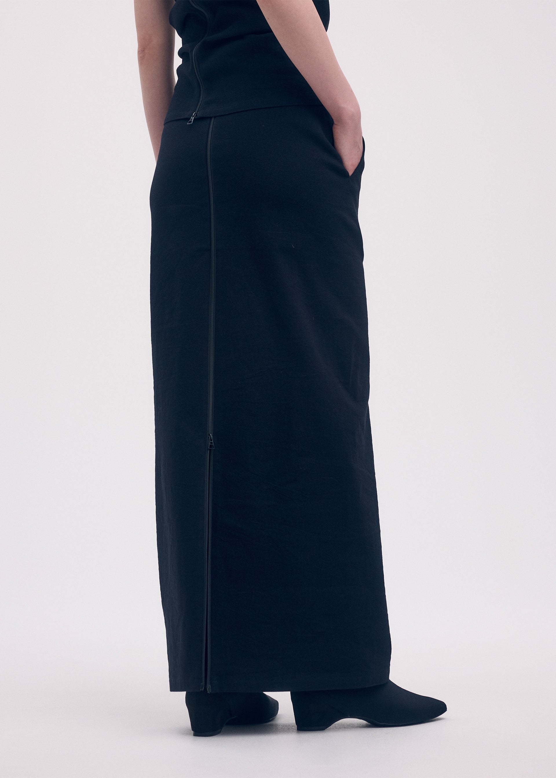 A model wears the ISSEY MIYAKE LIKE TORSO LIKE SHIRT skirt.