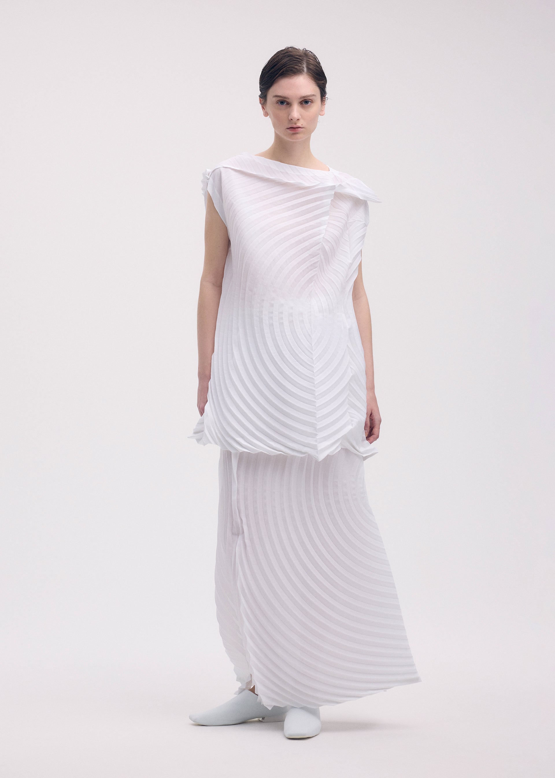A model wears the ISSEY MIYAKE PAPER BAG PLEATS skirt.