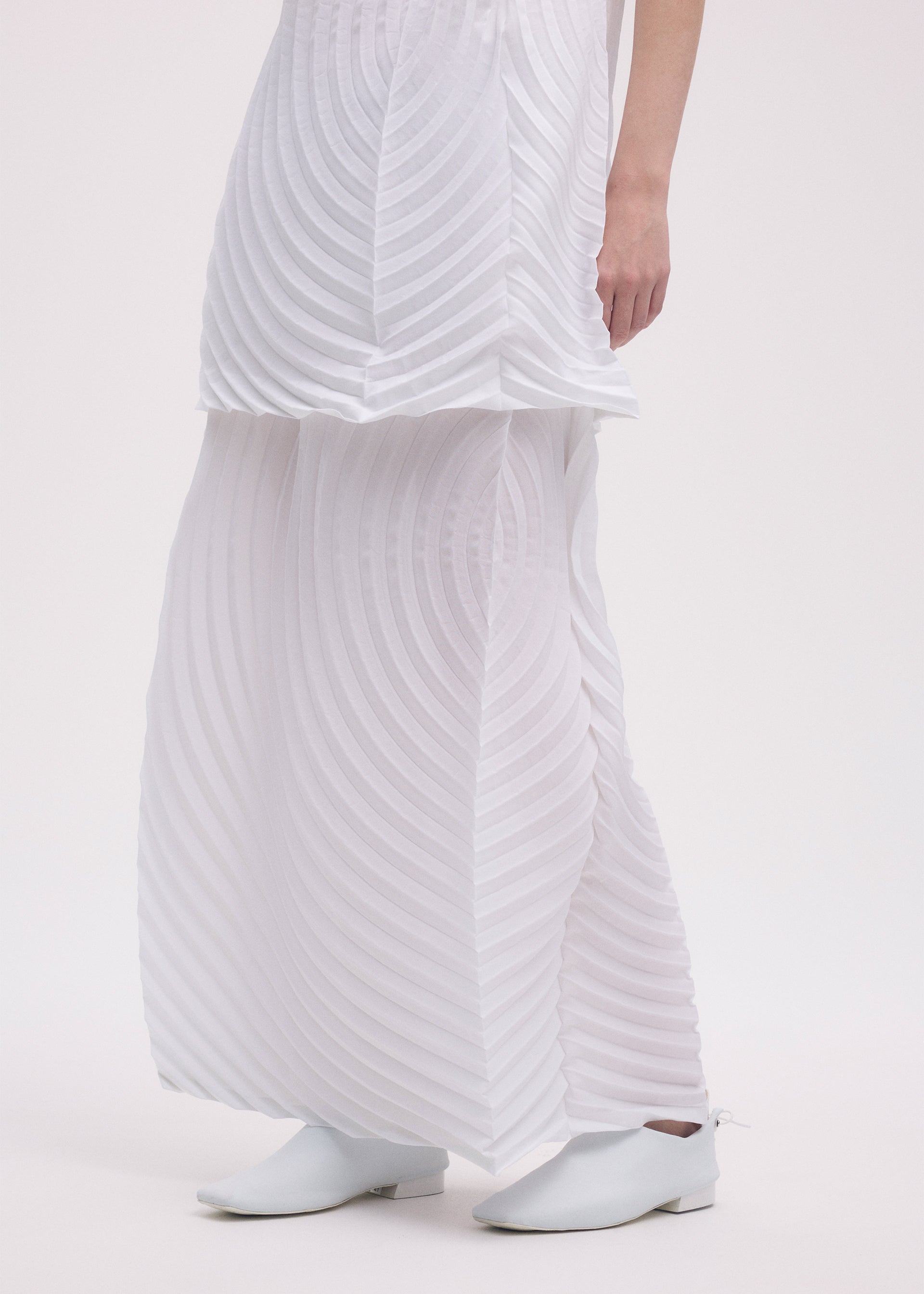 A model wears the ISSEY MIYAKE PAPER BAG PLEATS skirt.