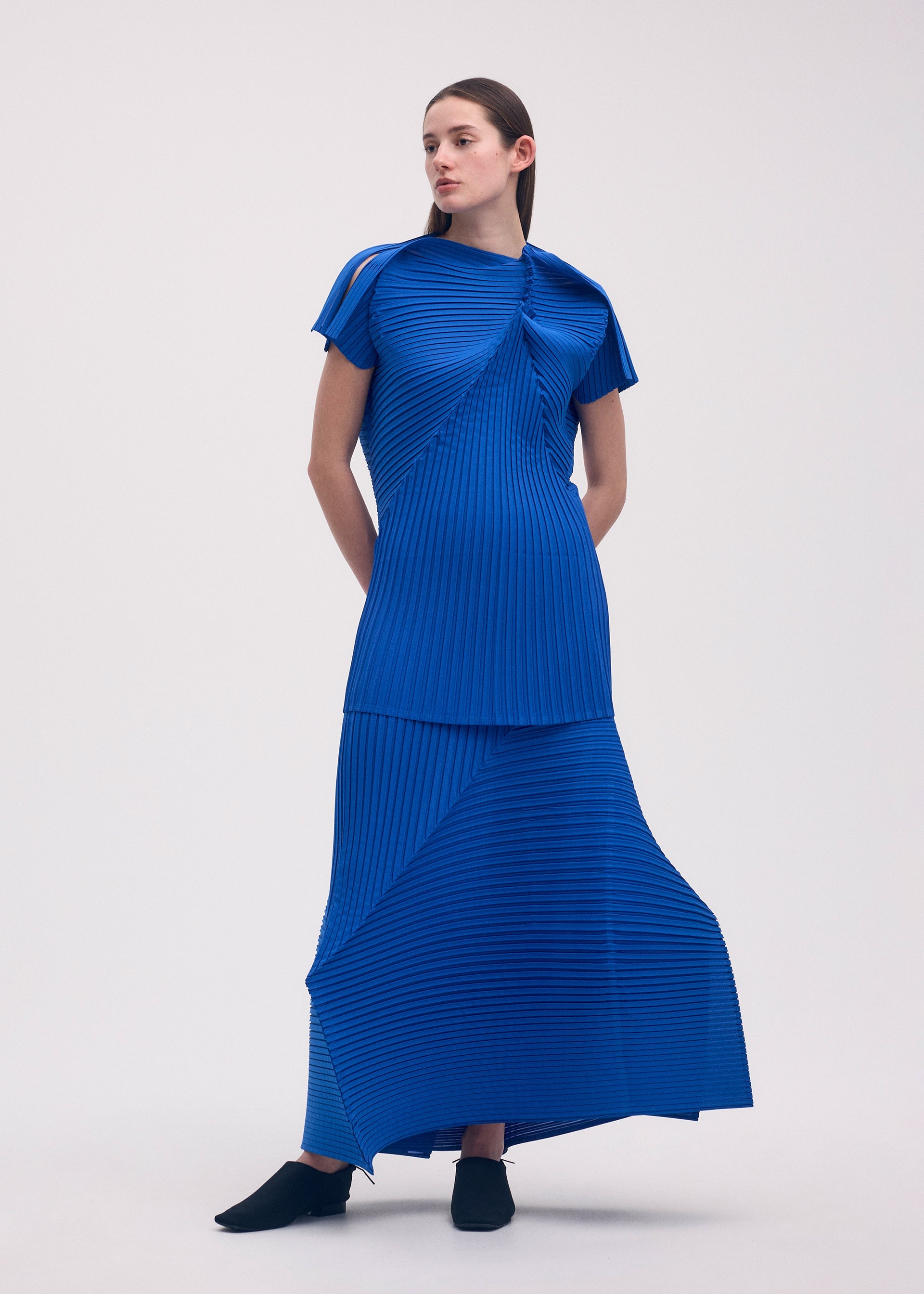 A model wears the ISSEY MIYAKE FOLD PLEATS skirt.